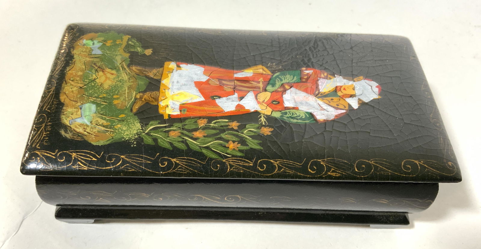 Signed Vintage Painted Asian Lacquered Trinket Box: Piece is signed illegibly. Trinket box is vintage. Piece appears to have hand painted elements. Trinket box is lidded. Top of piece has depiction of female figure standing in grass & flowers. Box is f