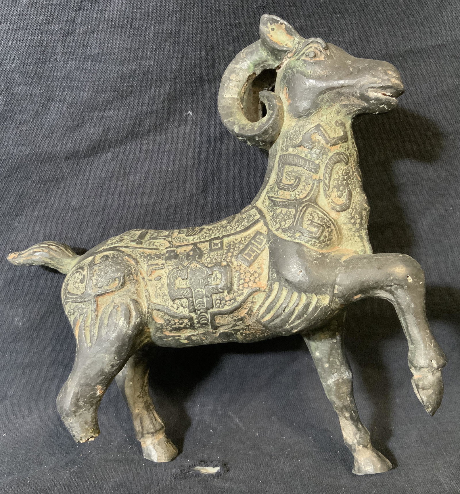 Metal Middle Eastern Ram Sculpture: Metal Middle eastern ram sculpture, no apparent inscriptions or markings, hollow sculpture with hole to the underside, geometric designs to body of piece, piece is missing back right leg, Piece measur