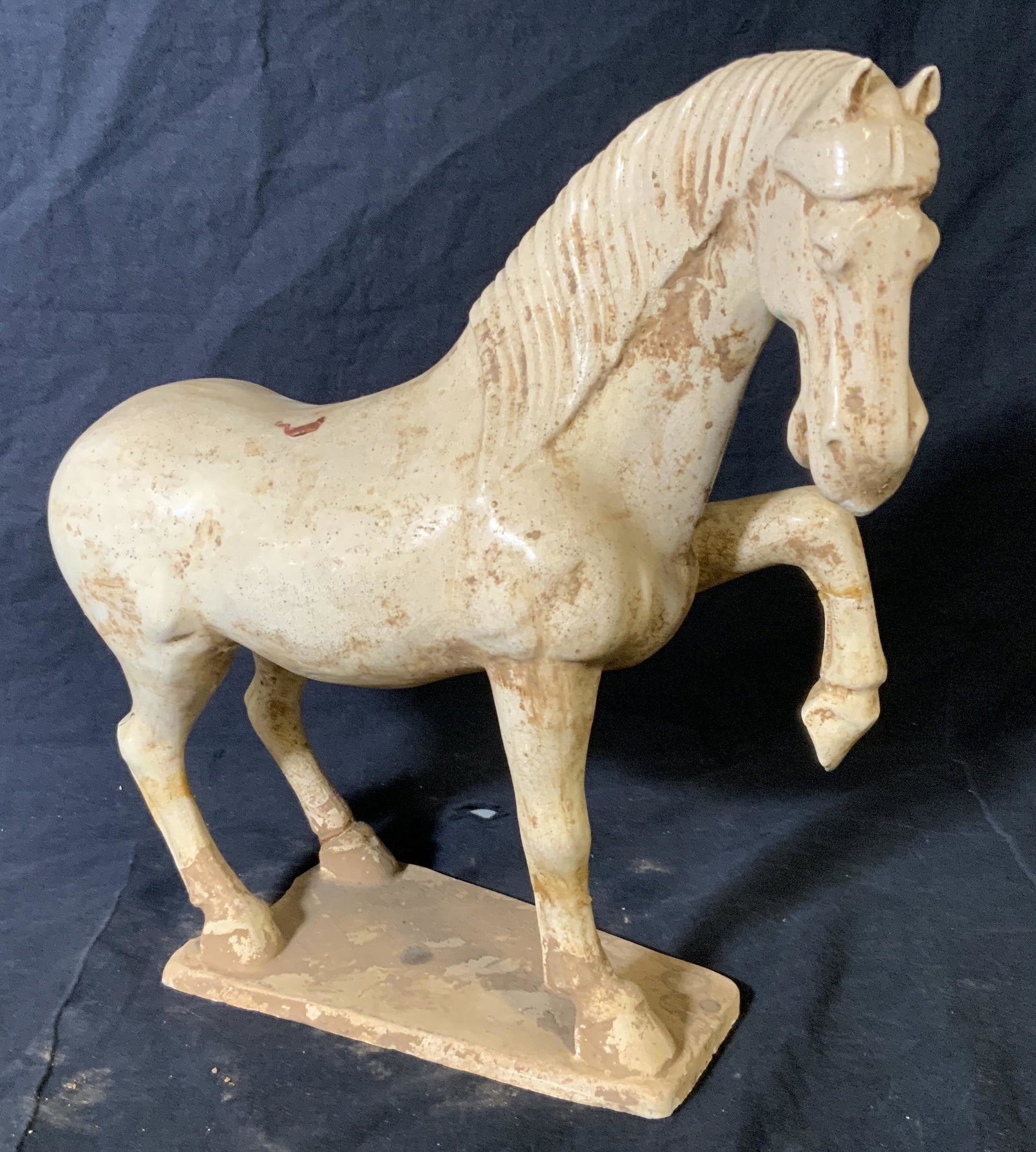 Porcelain Horse Statue, Decorative Arts: Porcelain horse statue, no apparent inscriptions or markings, subject a tan porcelain horse with front leg raised, tail to horse missing, some scuffs and chips to piece, piece measures approximately 1
