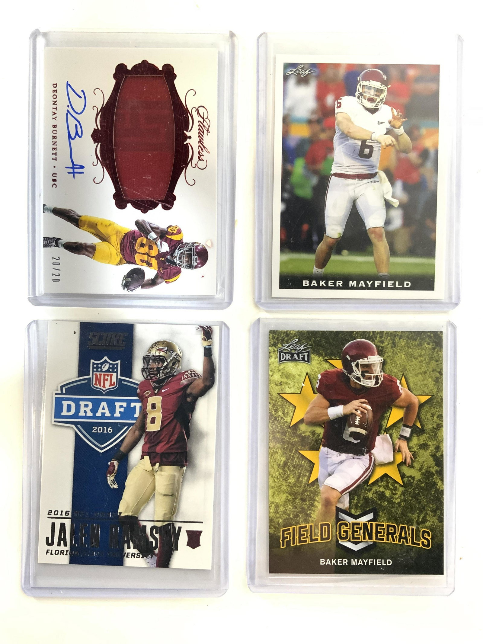 Lot 4 College Football Cards: Lot includes 4 college football cards including Baker Mayfield Leaf FG-01, Baker Mayfield Leaf no 07. Deontae Burnett Panini no RPA DB & Jalen Ramsey Panini No 10. All cards are in plastic casing. Eac
