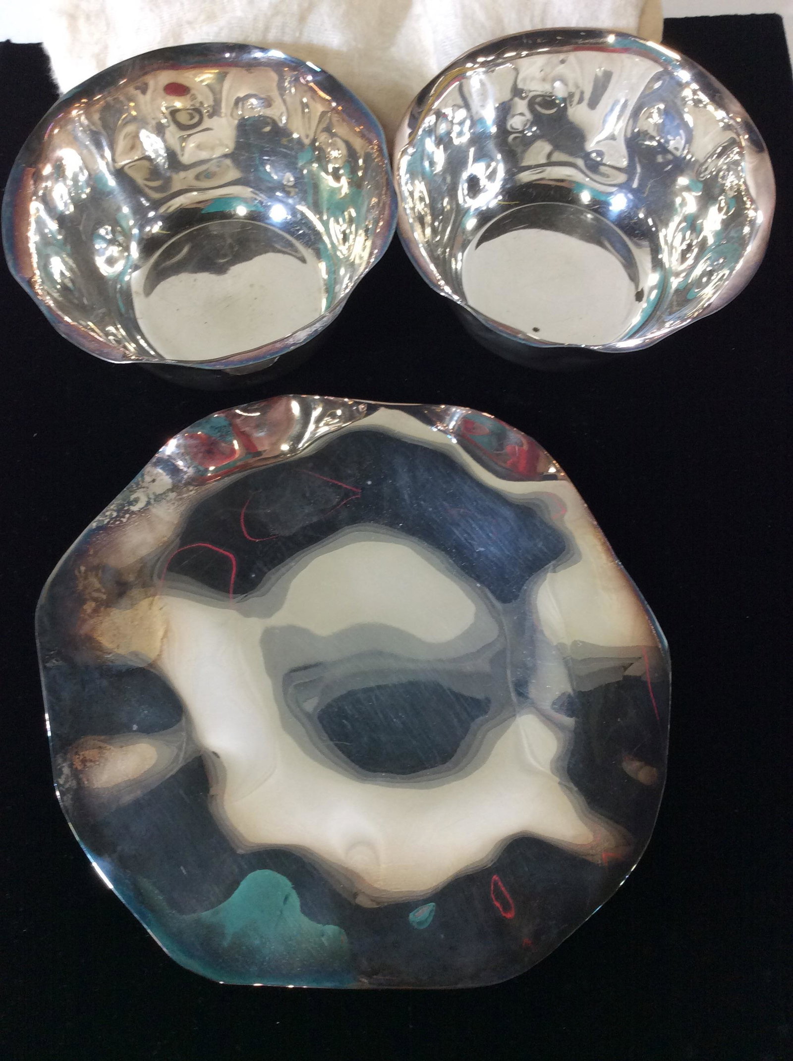 Set 3 Hammered Bowls And Plate: Organic form, wavy hammered Hollowware, possibly silver plated. Light tarnish on Plate. All come with protective Storage Cloth. Plate app 7 in. Bowls 4.5 in wide, 2.5 in ht. Vintage. Collectible Hollo