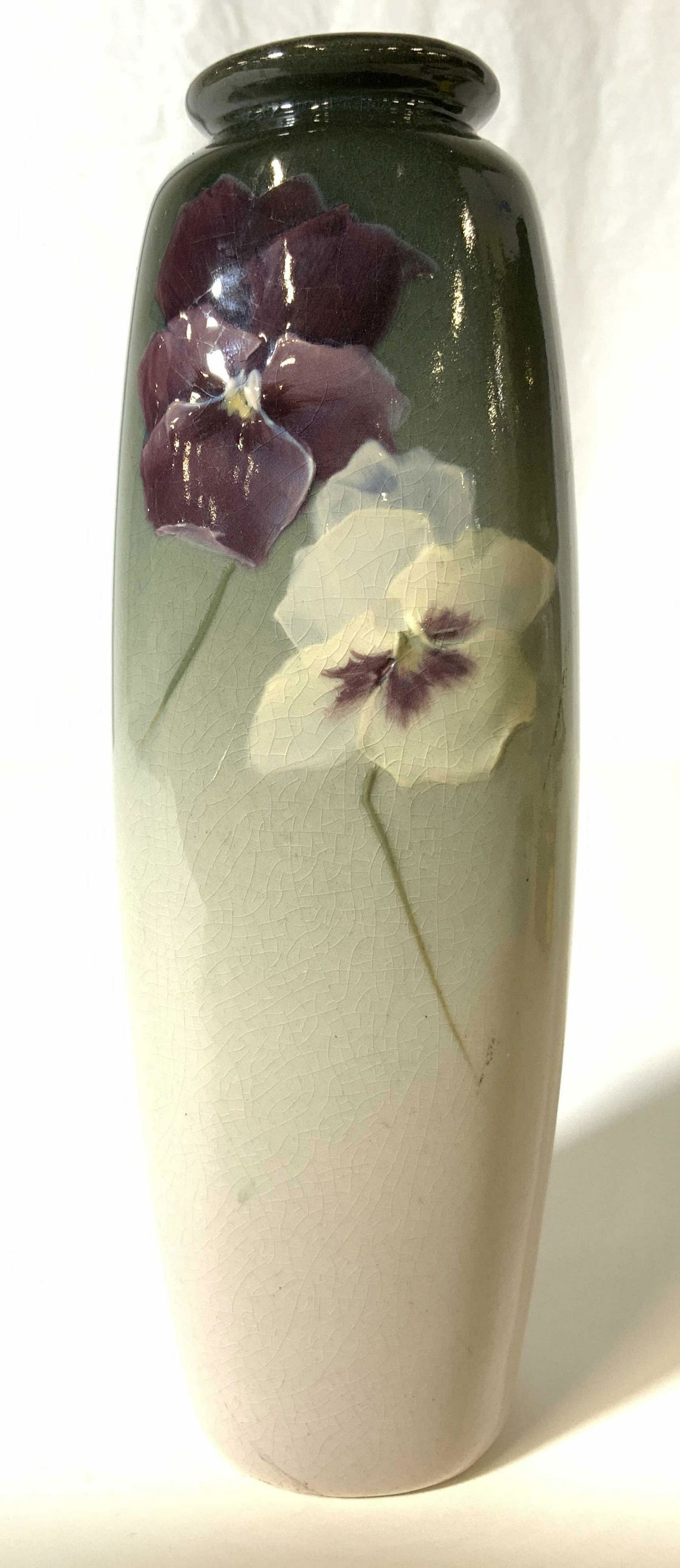 Signed Painted Floral Detailed Porcelain Vase: Vase is signed illegibly on underside. Vase is porcelain. Piece appears to possibly be hand painted with purple, white, green and blue floral detail. Vase measures approx 8 inches tall 2.5 inches wide