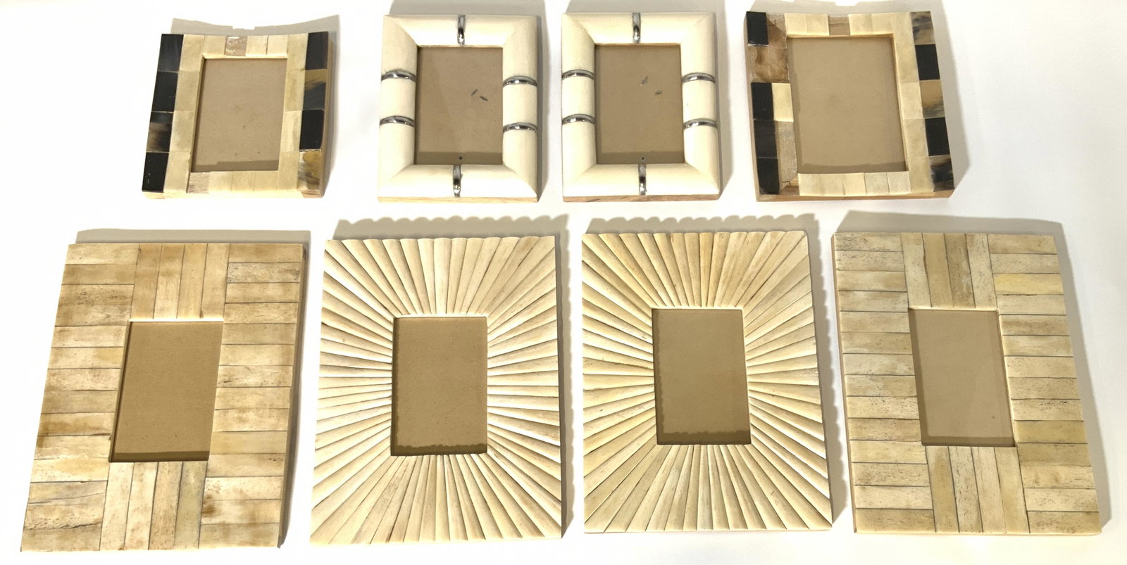 Lot 8 Carved Bone Picture Frames: Lot includes 8 picture frames. Each appear to be carved bone. Lot includes 2 rectangular frames with sunburst style structured detail, 2 rectangular frames w silver toned accent detail, 2 frames with 