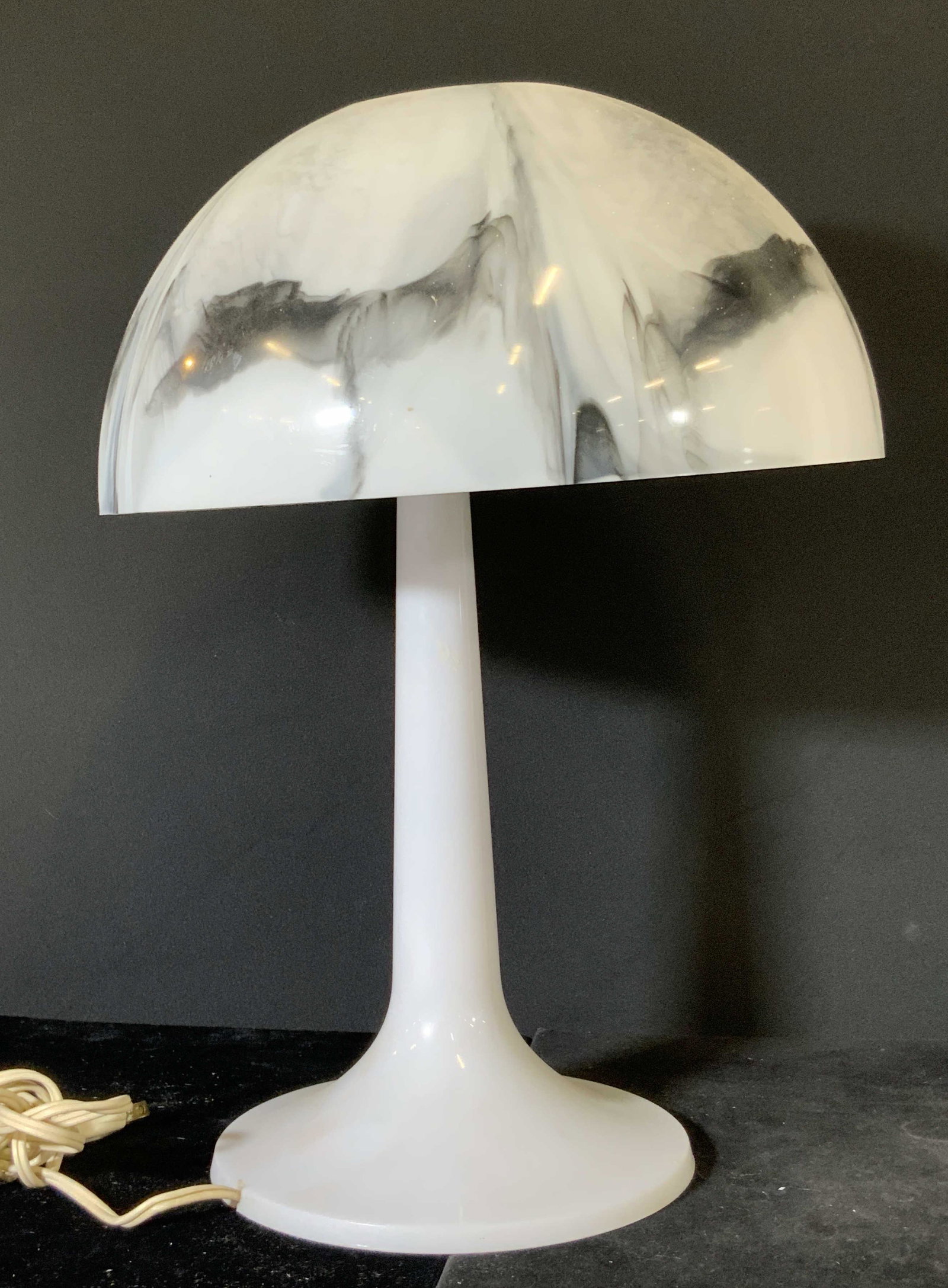 UNDERWRITERS LABORATORIES Marble Style Lamp: A marble style tabletop lamp. Possibly crafted from Bakelite. Primarily white with marbled black hues throughout. Cord is beige toned. Lamp untested. Sticker on underside reads: Underwriters Laborator