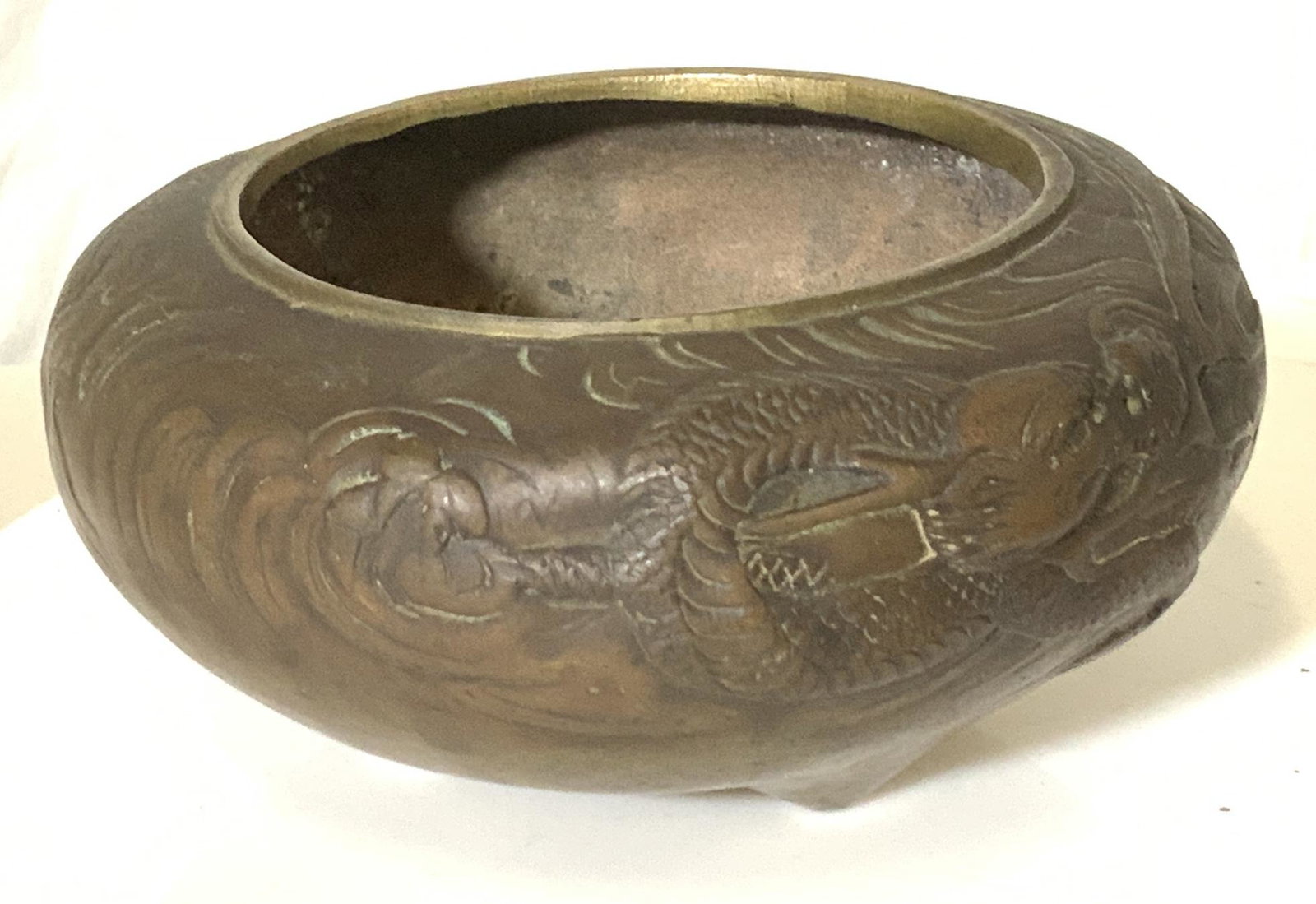 Embossed Asian Dragon Bronze Vntg Bowl: This bowl has embossed image of Chinese dragon with clawed feet, fading through the thunderous cloud design. Medium weight piece has 3 feet to prop it and give it prominence. Measures 5 in. Wide, 2.25