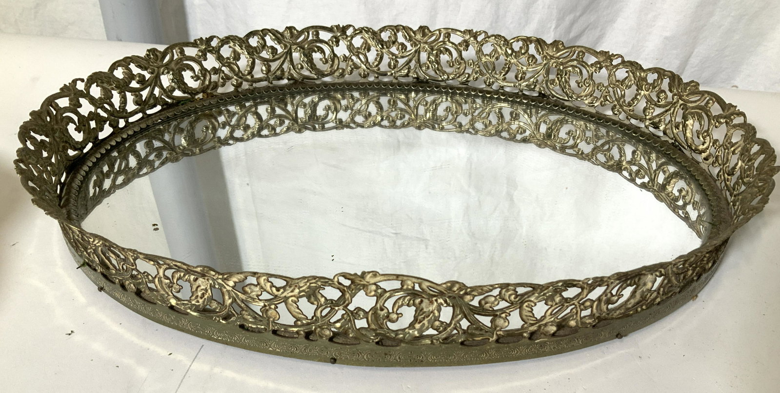 Vintage Vanity Mirror Tray w Pierced Brass Rim: Vintage mirror tray for dresser top, bathroom, table decor, more. Pierced brass metal rim with Victorian interlocking scroll pattern. Footed underside. 16 x 11.5 in. Rim Ht 2 in. Property of Multi Gen