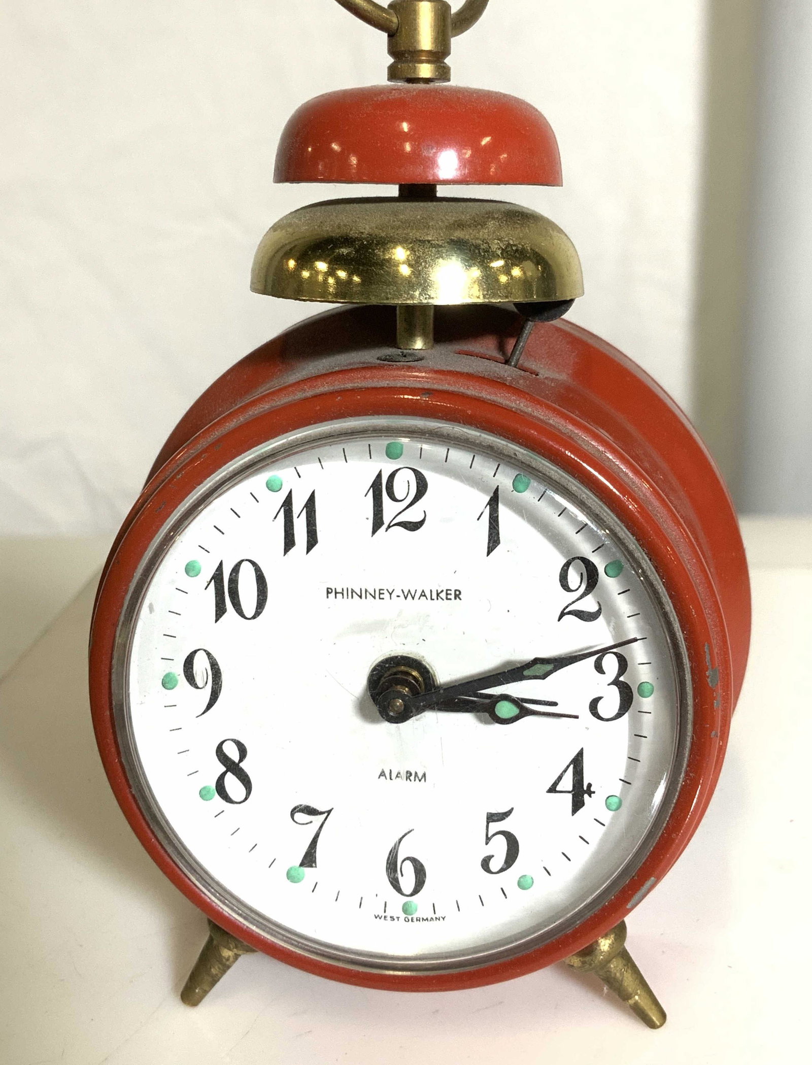 Phinney Walker Bell Alarm Clock, West Germany: Vintage alarm clock, wind up, on/ off alarm, red enamel, vintage bell form alarm clock. Reads West Germany on verso. Brass accents. 3 in. Property of Multi Generation Brooklyn Collector’s Estate.Phi