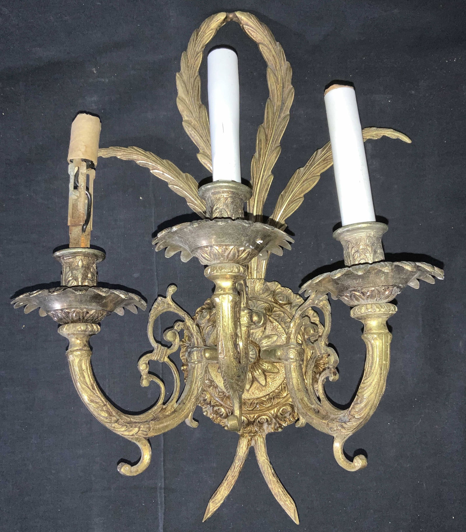 Three Arm Feather Back Rococo Gilt Brass Sconce: Vintage brass/ bronze sconce, gilt coating, triple candle chandelier light a la candelabra. Needs screw to hold up featherback backside design. 16.5 in. Long, 12 in. W. Depth from wall app 6.25 in. Li
