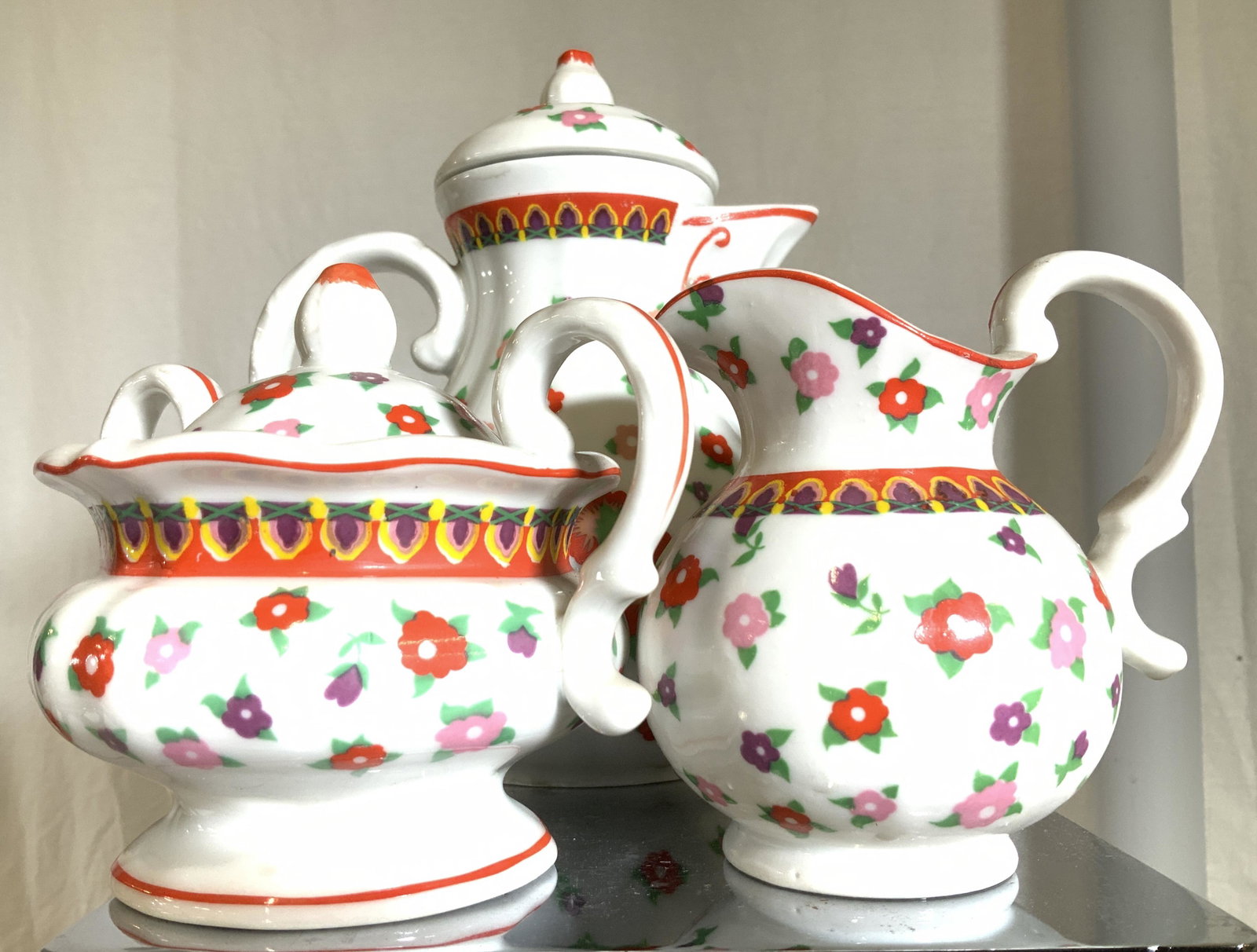 Set 3 Porcelain Happy Flower Tea Set Tableware: White ware porcelain with bright colored flowers. Set includes tea pot with lid ( 8 in ht, 6 in width), empire handle sugar bowl with lid and creamer. Hand painted. Up cycle for sugar packets, trinket
