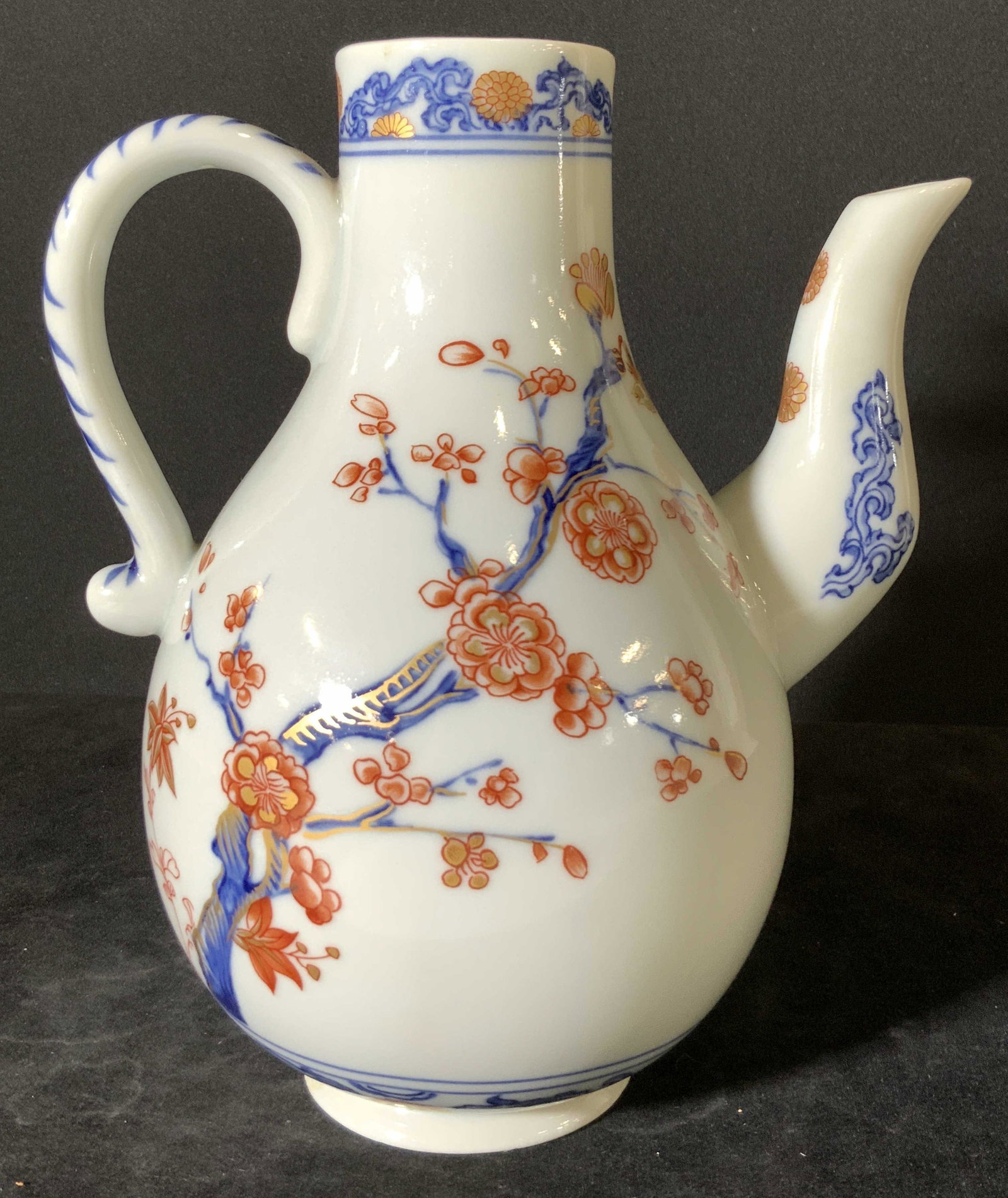 MMA MOTTAHEDEH Signed Imari Style Ceramic Pourer: A white porcelain pourer / pitcher. Decorated with Imari style coloring and patterns. Floral and bird motifs. Orange, blue, and gilt hues. Underside reads: ADAPTED FROM A CHINESE IMARI SCROLL PLATE, K