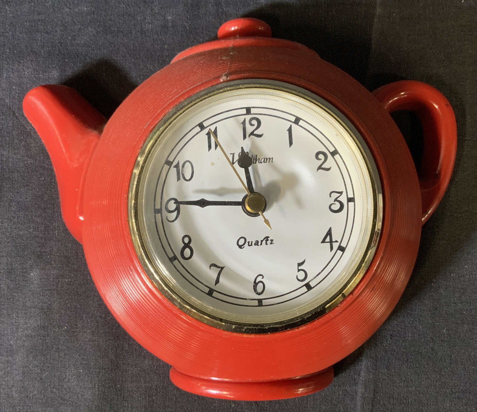 WALTHAM Tea Pot Clock: WALTHAM Tea Pot Clock, inscriptions read ‘Waltham Quartz Model No 11’, measures 6 1/2 x 7 3/4 inches at widest point, cracks and repairs to piece from previous usage, not tested for functionality,