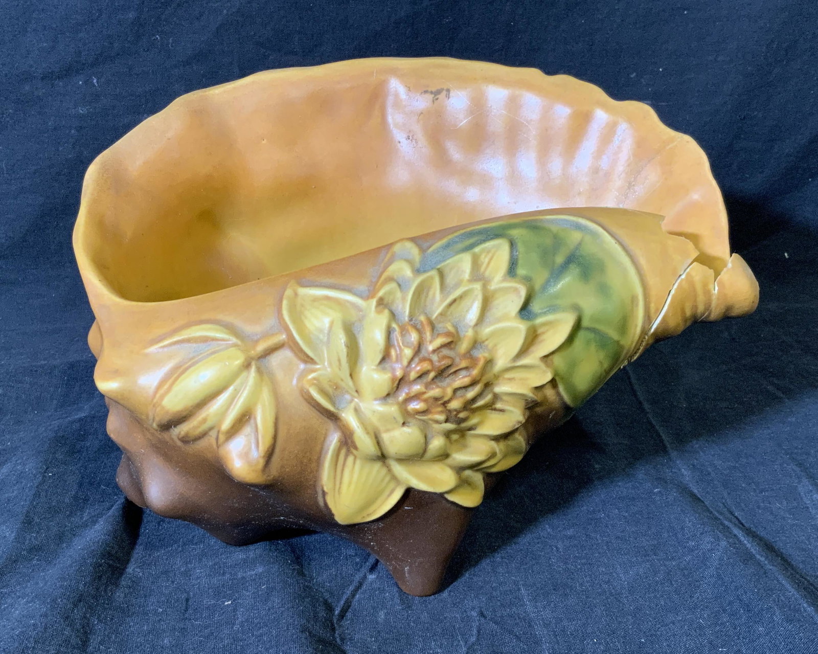 Roseville Porcelain Seashell Sculpture Vessel: Roseville Porcelain Seashell Sculpture, underside of shell reads ‘Roseville USA 11.38.8’, cracks and breaks to shell, piece measures 6.5 inches tall and 10 inches wide, surface of shell displays a