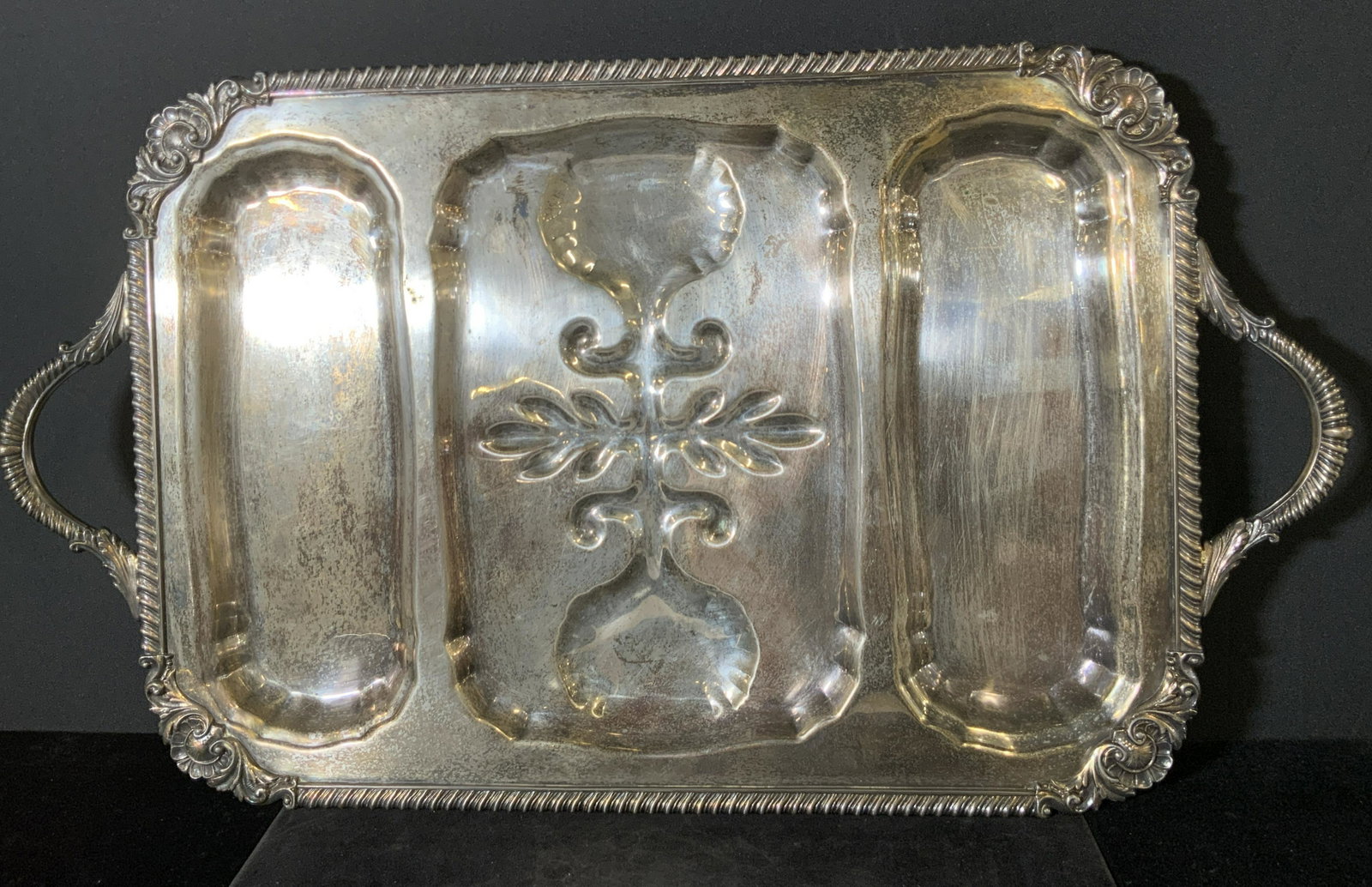 Oversized ENGLISH SILVER PLATED Serving Tray: A oversized embossed silver plated tray. Rim is decorated with Victorian style metalwork. Piece has twin handles. Piece has four feet on the underside. Underside of piece is hallmarked & signed ENGLIS