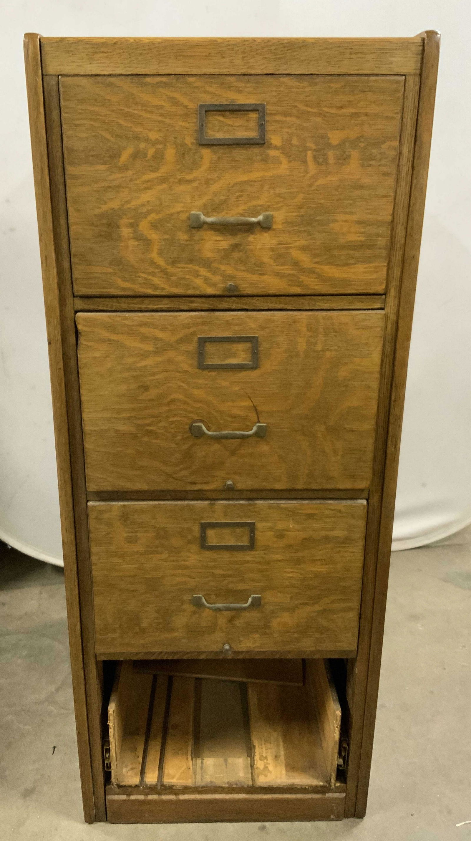Vintage Wooden Filing Cabinet: Vintage wooden filing cabinet. Four drawers, bottom drawer needs repair or replacing. Measures approx 52 inches H, 21 inches W, 27 inches deep. Wear is consistent with age and use. Property of multi g