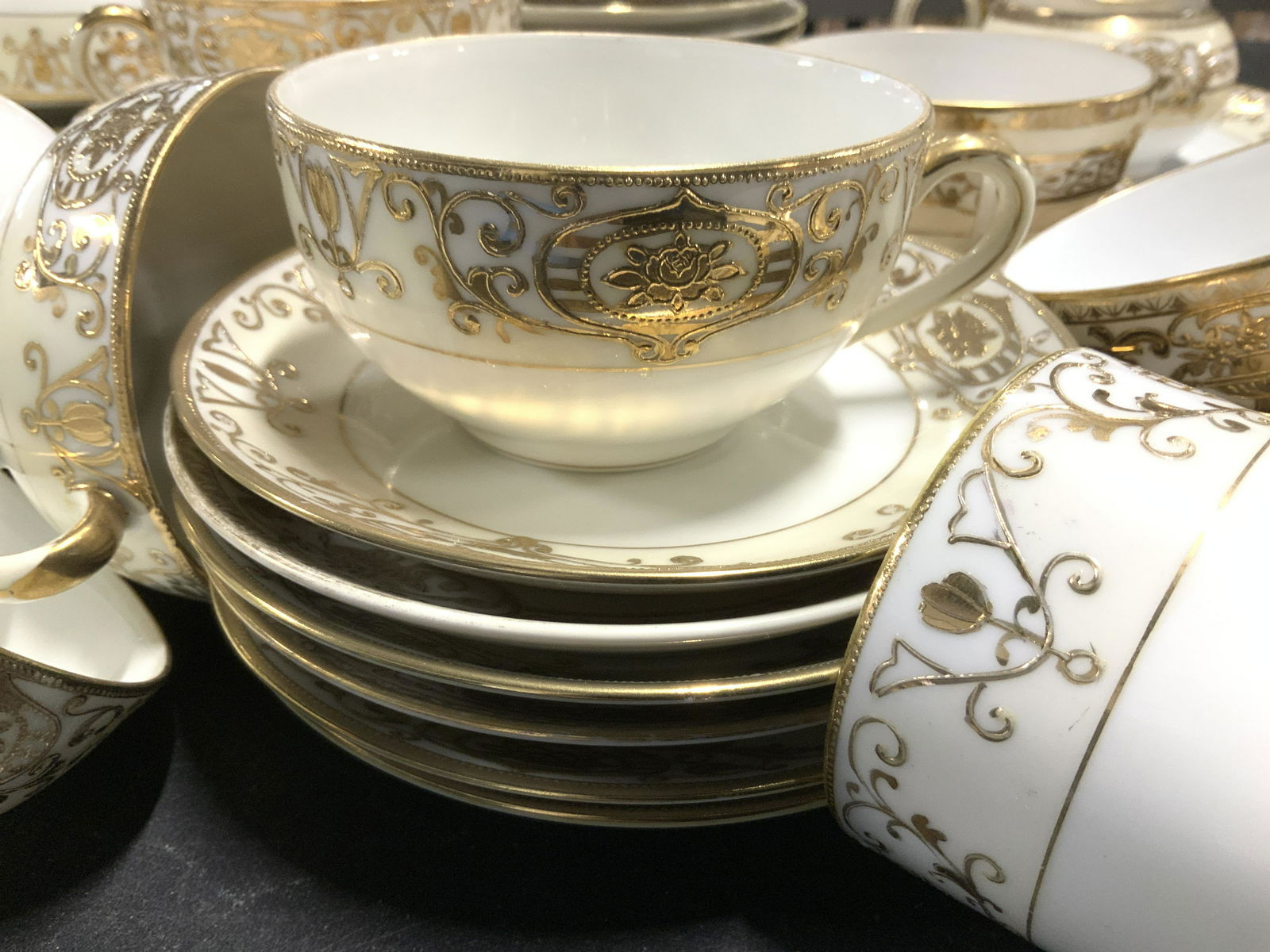 NORITAKE Gilt White Porcelain Tea & Plate Sets 55: Two partial sets of NORITAKE CHINA, both gilt and white porcelain, slightly different pattern and all combining tableware. ALL Hand painted, Japanese Porcelain. Hallmarked NORITAKE JAPAN with M symbol