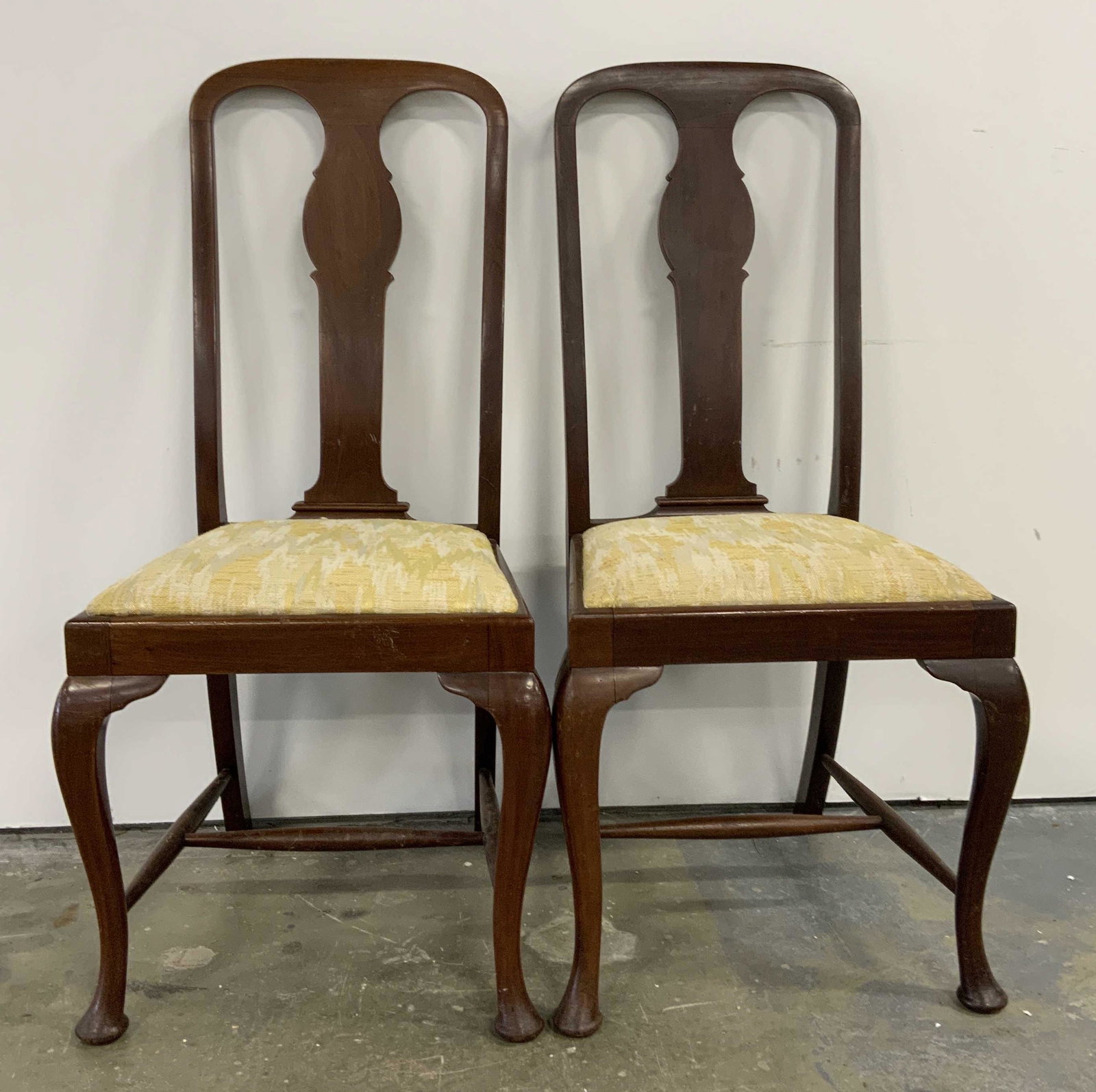 Pair Antique Upholstered Carved Wooden Side Chairs: Pair antique wooden side chairs. Each chair includes an upholstered cushion, cushions are lime toned. Backs are fiddle backed, front legs are cabriole, and back legs are saber shaped. Legs are connect