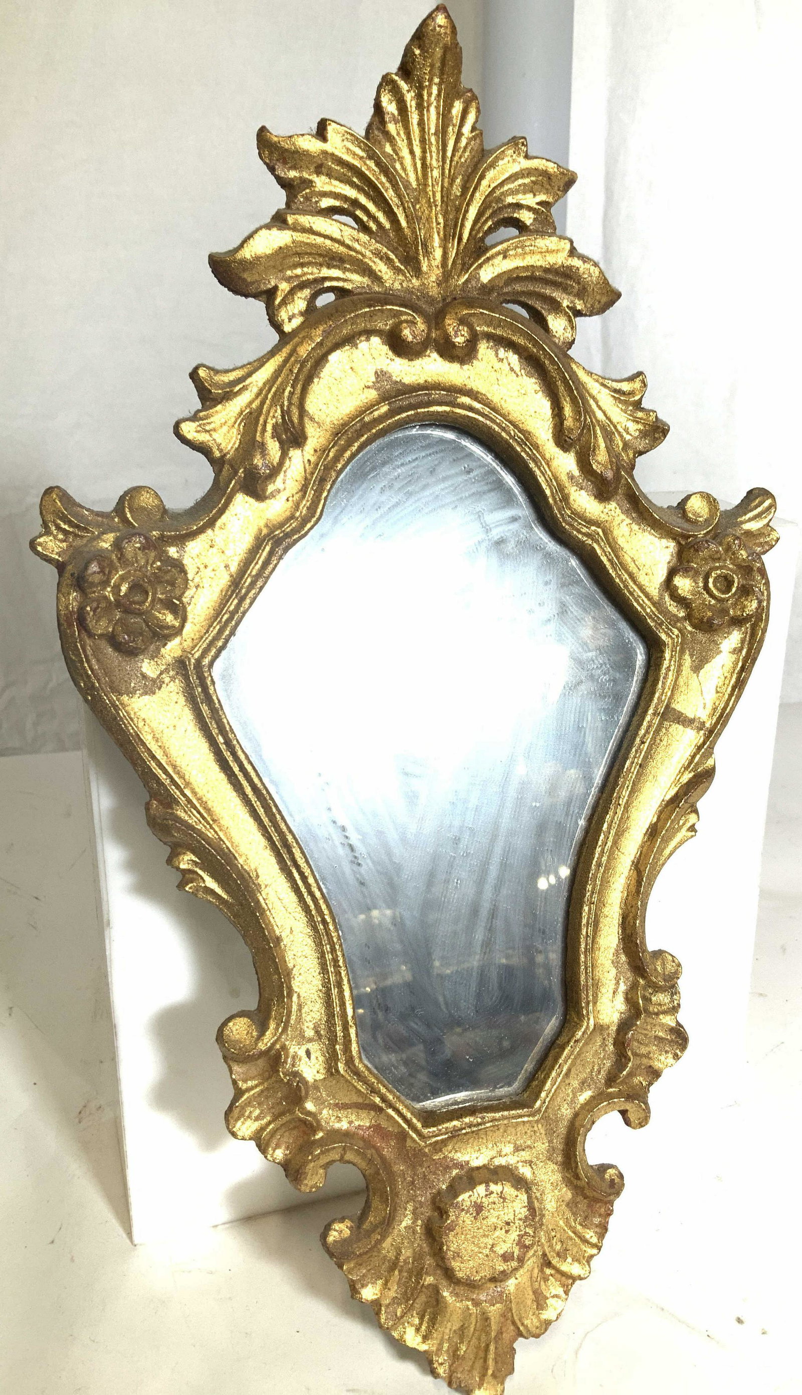 Vintage Baroque Gilt Wood Mirror: Lightweight mirror, gold leaf over wood with reddish hues, Fleur de lis crest. Hanger on verso. Measures 13.25 in. L, 7.5 in. W property of multi generational Brooklyn collectors estate, Baroque Style