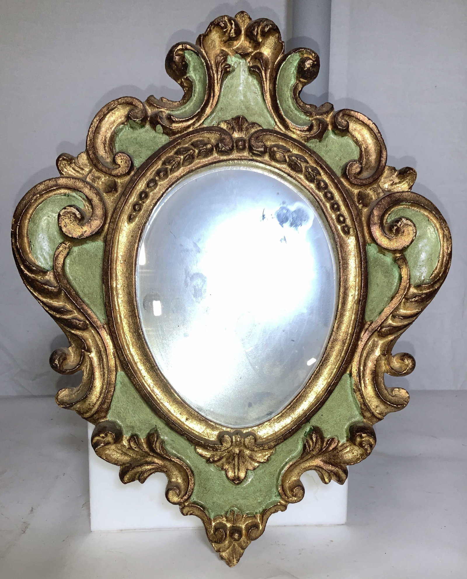 Hand Painted Gilt Wood Rococo Wall Mirror: Lightweight mirror, gold leaf over wood with pastel green paint. Hanger on verso. Measures 15. 25 in. L, 12.5 in. W property of multi generational Brooklyn collectors estate, Venetian Style mirror, go