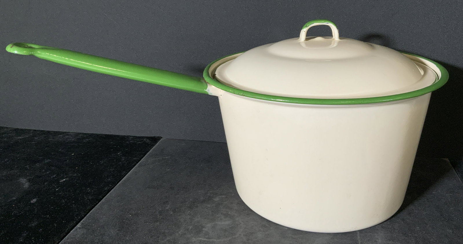 Vintage Enamelware Stovetop Lidded Pot: A vintage enamelware stovetop pot. Beige toned with green accents. Approx. 5.5H x 16W in. Piece is part of a larger collection of retro vintage kitchenware. Property of multigenerational Brooklyn Coll