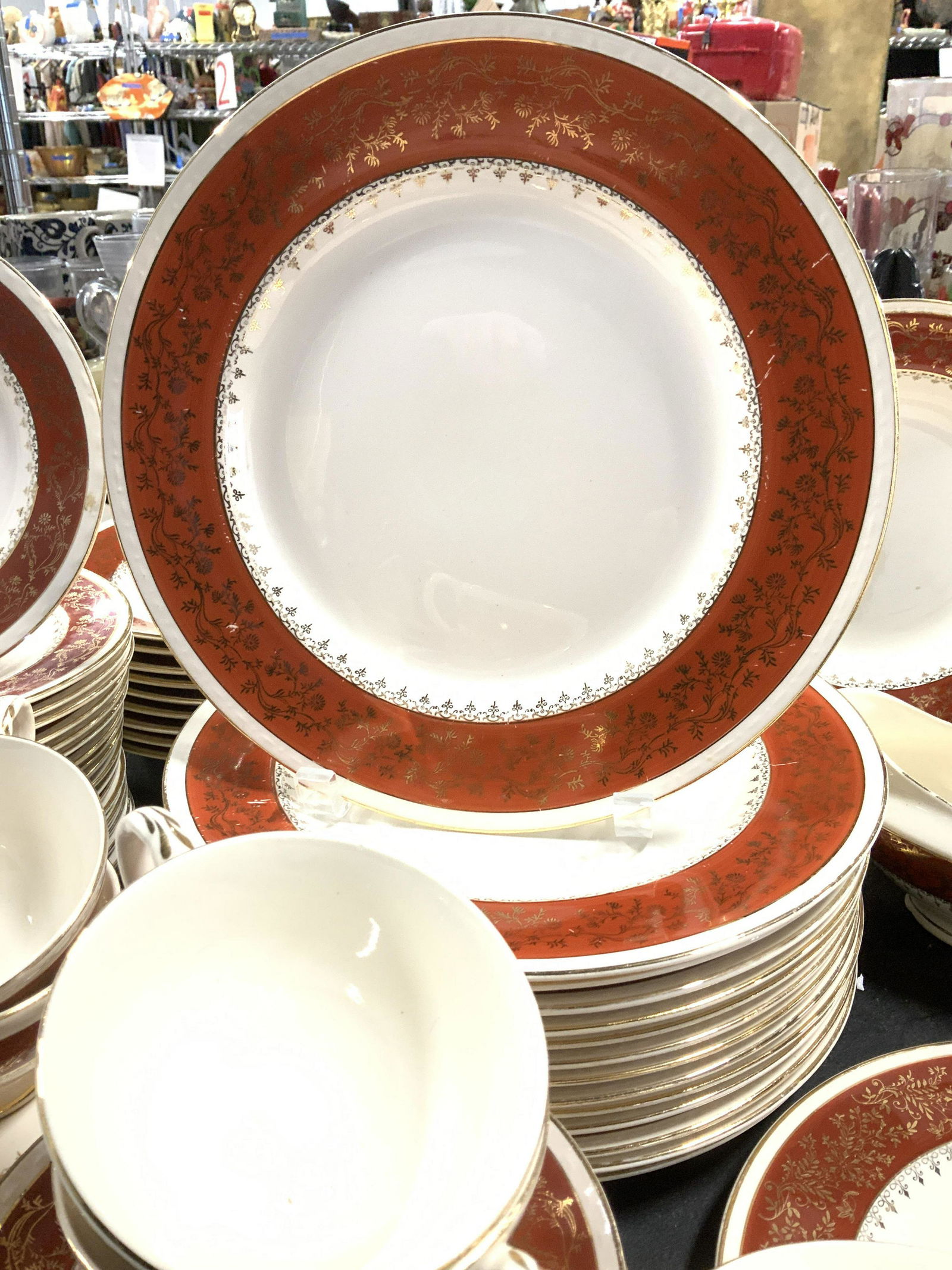 CRAFTSMAN 18k Gilt Porcelain Chinaware set 128: Beige colored porcelain China set with hand painted orange border and 18k Gold Gilt rim and floral design. 13 dinner plates, 2 serving platters, pedestal sugar bowl with lid, 2 gravy boats, pedestal c