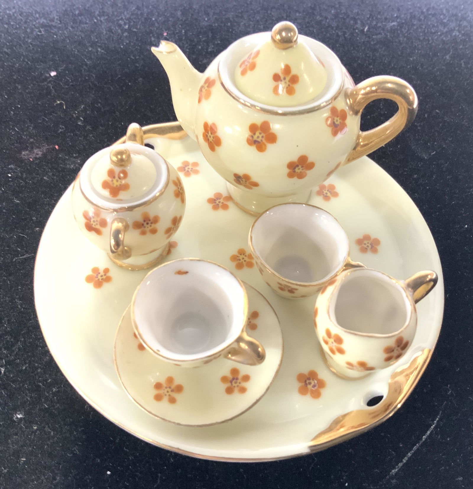 MARUYAMA Porcelain Miniature Tea Set 7: Hand painted flower motif doll house miniature China tea set. Teapot and sugar bowl both have lids. 1 plate, 2 tea cups, creamer and platter, 3.5 in. diameter. Gilt rim. Hallmarked pieces. Made in Occ