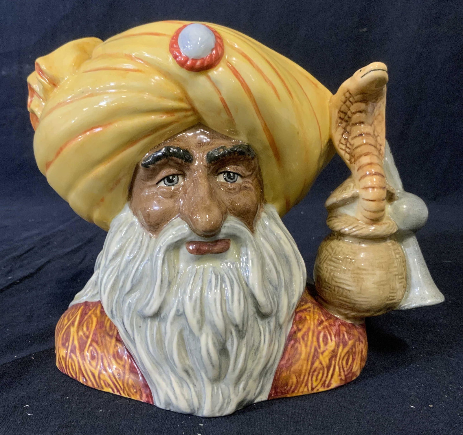 ROYAL DOULTON THE SNAKE CHARMER Character Jug: Vintage character jug, THE SNAKE CHARMER, by ROYAL DOULTON. Documentation included provides details about piece. Modeled by Stanley James Taylor. Underside reads as HAND MADE AND HAND DECORATED, ROYAL