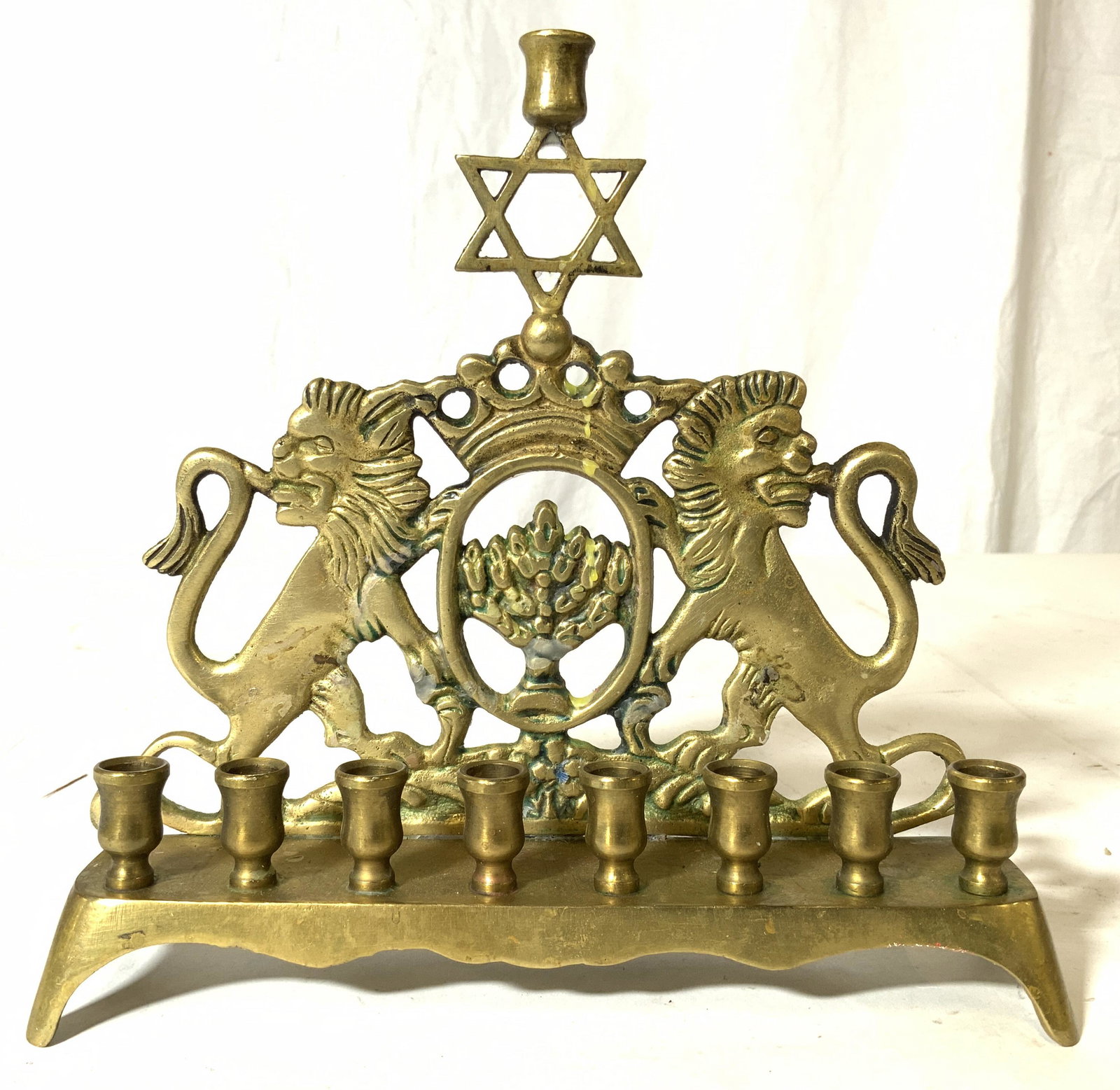 Vintage Gold Toned Brass Judaica Menorah: Menorah is gold toned toned and brass. Piece is vintage possibly antique. Menorah has Star of David detail in center. Piece has lion figural on each side. Piece measures approx 7.5 inches 8 inches lon