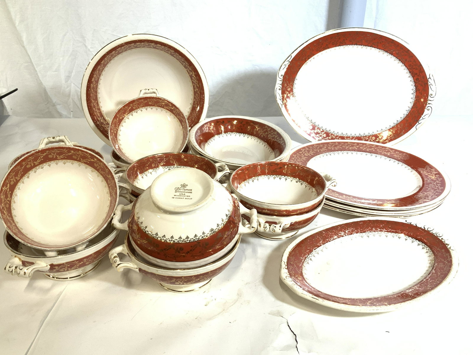 CRAFTSMAN DINNERWARE Part Set 20: Cream colored vintage porcelain dinnerware, partial set, 18K gilt of floral detail on orange border, Hallmarked. Partial set consists of 3 dinner plates, 1 round serving bowl, 1 med sized platter, 1 s