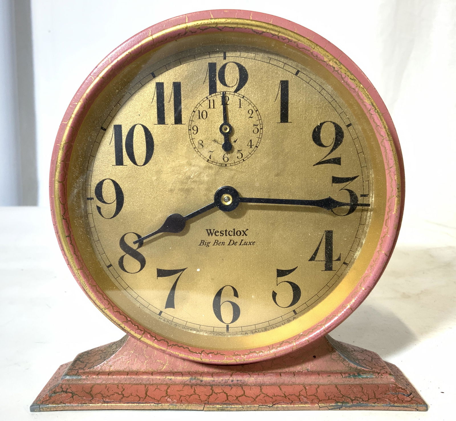 Vintage WESTCLOX BIG BEN DE LUXE Alarm Clock: Clock face reads WESTCLOX BIG BEN DE LUXE. Clock is pink toned and appears to be tole. Clock face is gold toned with black numericals. Piece measures approx 6 inches tall & wide 3 inches deep. Clock,
