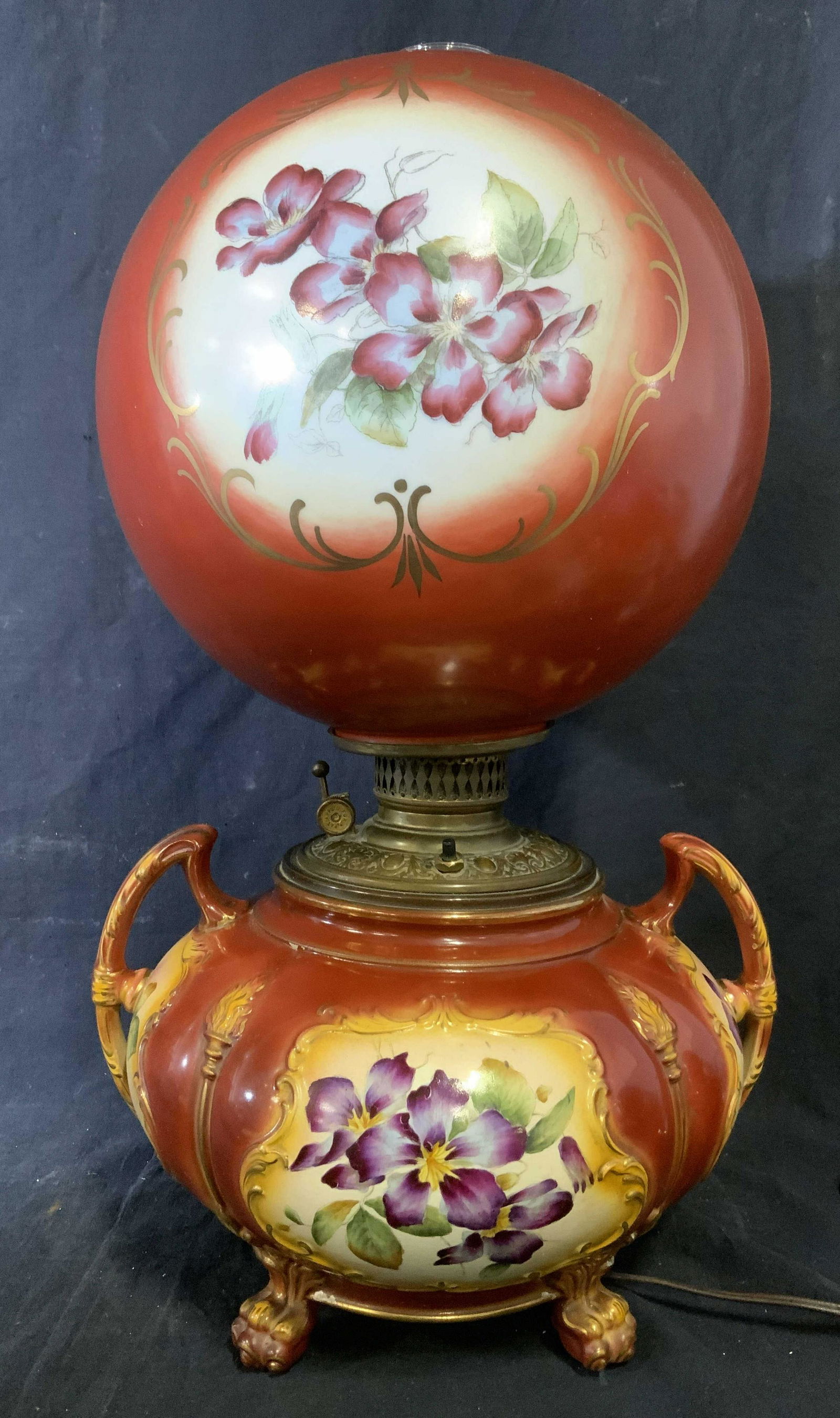 Victorian Hand Painted Gone With The Wind Lamp: Vintage, possibly antique, gone with the wind lamp. Lamp shade and body are hand painted. Handles are on the body, floral illustrations decorate lamp shade and body. Lamp is footed, cast to resemble p