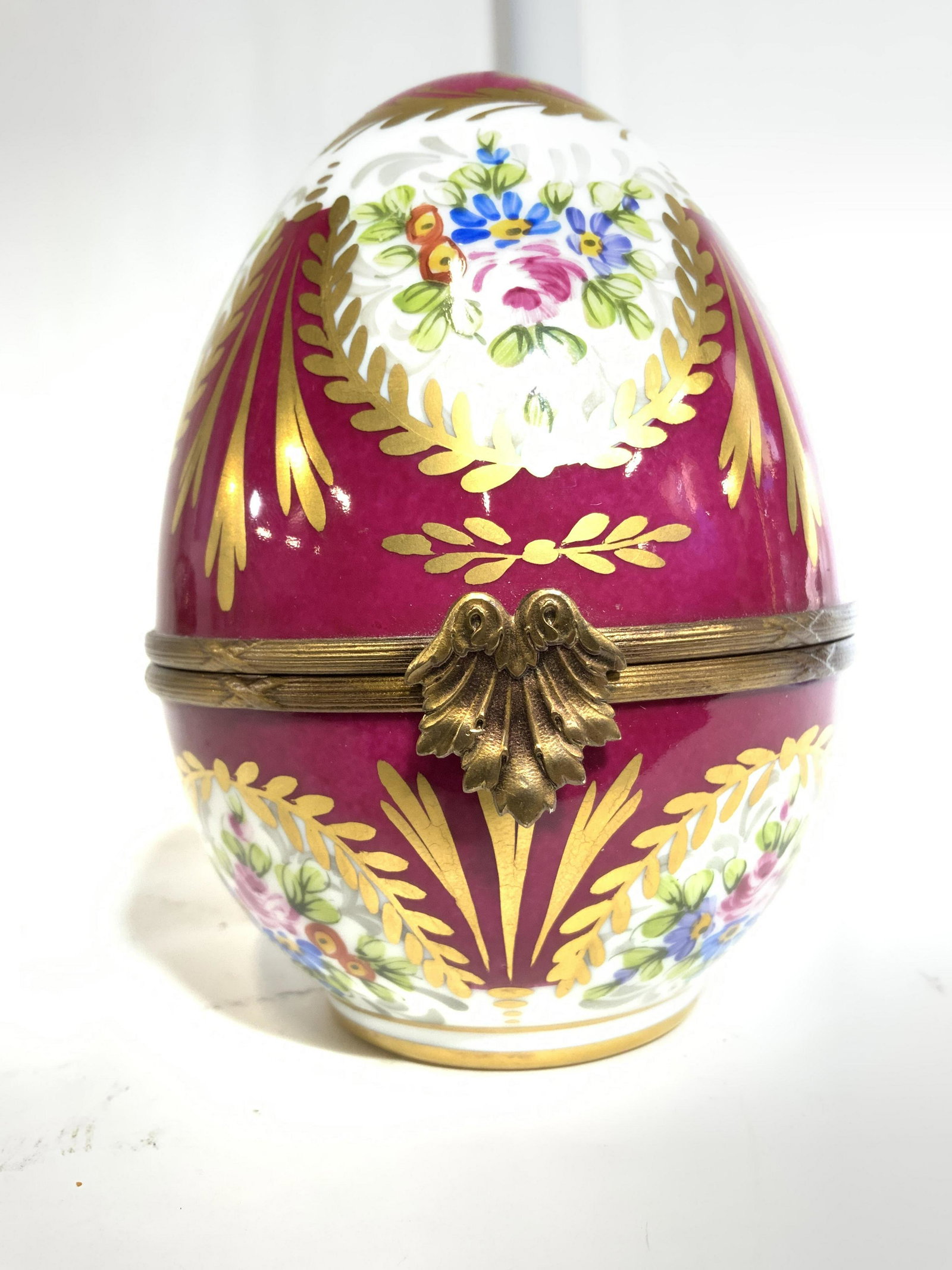 LIMOGES FRANCE Hand Painted Porcelain Egg Box: Underside is marked LIMOGES FRANCE. Keepsake box is egg shaped and porcelain. Piece has intricate multi toned hand painted floral & leaf detail. Piece measures approx 5 inches tall 3.5 inches wide. Li