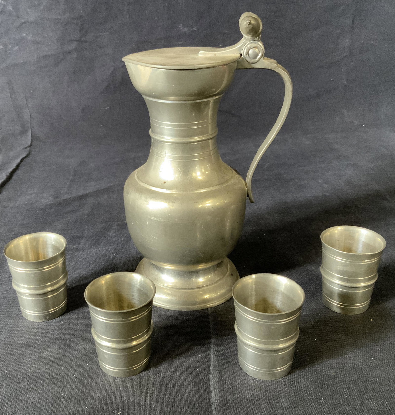 Vintage GENEVE Pewter Flagon & Serving Cups: Vintage GENEVE Pewter Flagon & Serving Cups, inscription to base reads ‘GENEVE Eaton Fin’, cups nest inside flagon, flagon measures 6 7/8 inches tall x 4 1/8 inches at widest point, cups measure 1