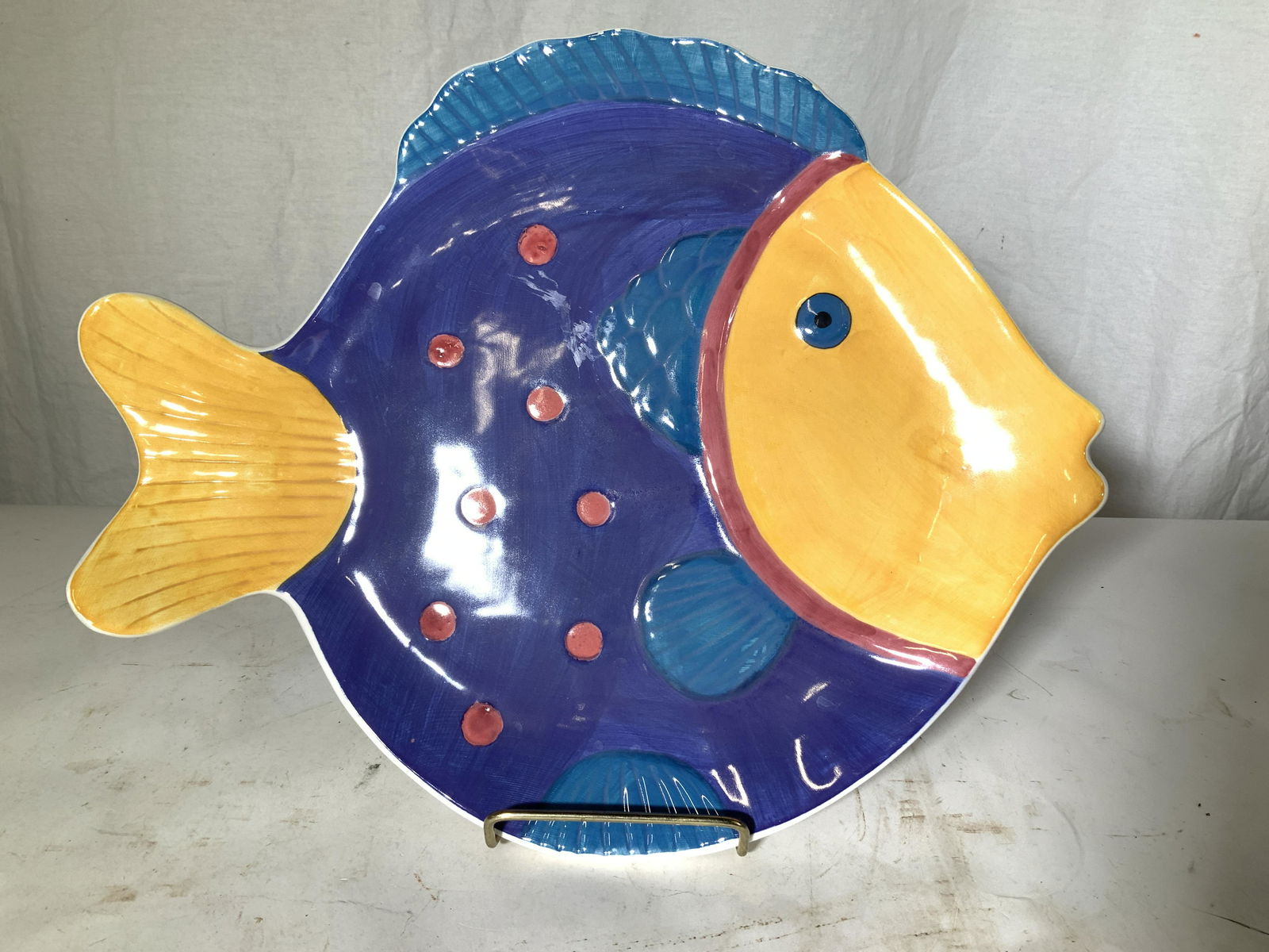 Hand Painted Colorful Ceramic Fish Plate: Happy fish plate with bright color, aqua, yellow, purple. Hand painted on white porcelain. App 14 in. Long, 11 in. W. Properly of Multi Generation Brooklyn Collector’s Estate, from Collector’s vin