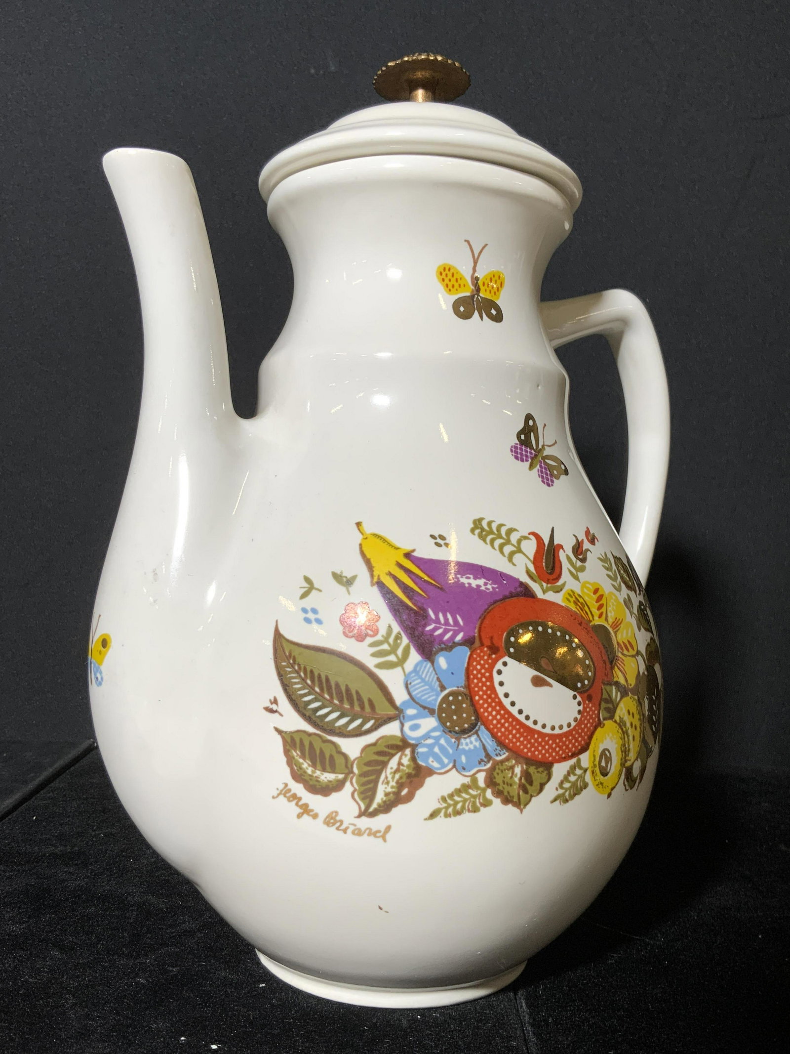 GEORGE BRIARD Signed Vintage Porcelain Teapot: A white porcelain lidded teapot decorated with vibrant painted fruits, vegetables, and florals. Gilt tone accents along the entire edible nature motif. Under the frontside decor it reads GEORGE BRIARD