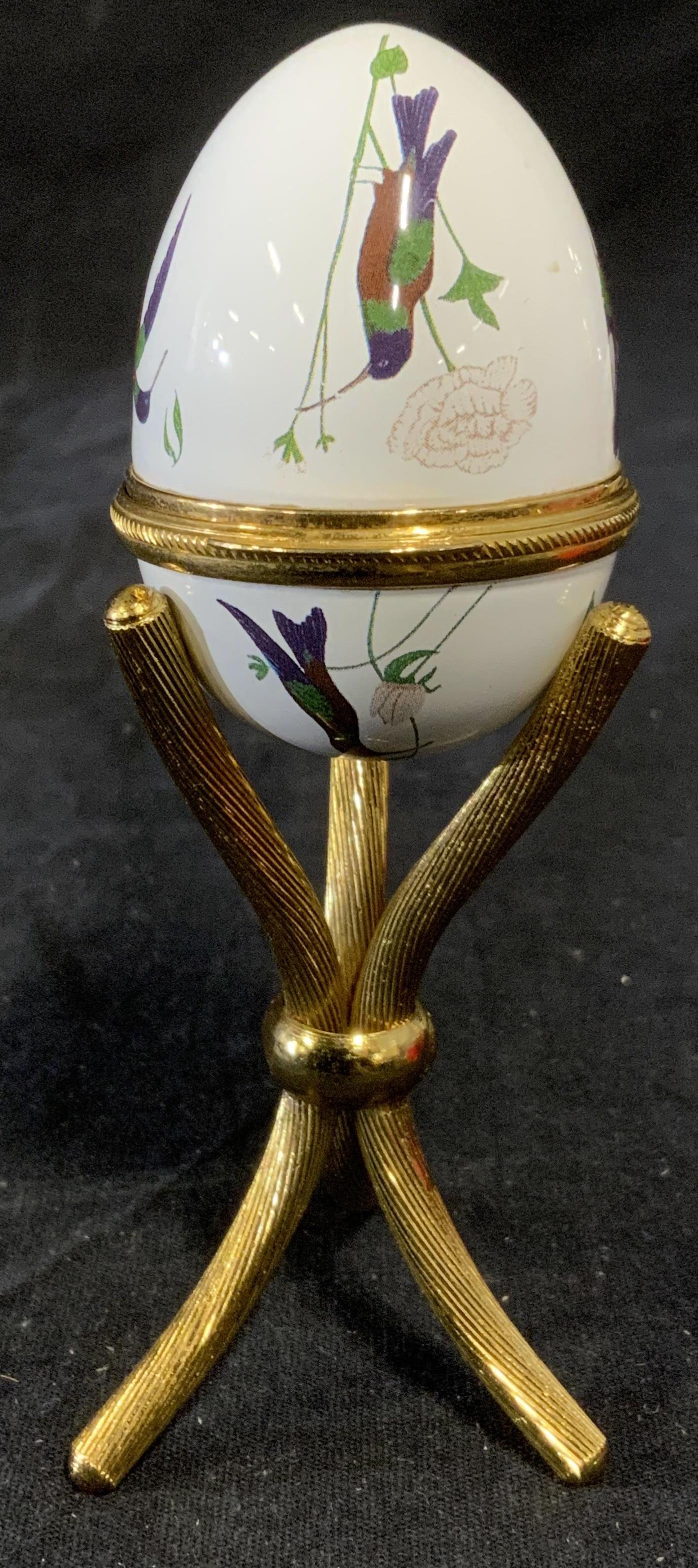 Vintage ALASTOR ENAMELS Decorative Egg: Vintage decorative enameled egg. Egg is a trinket/keepsake box. ALASTOR ENAMELS, MADE IN ENGLAND is stamped under the lid. Includes a gilded metal stand. Measures approx 4 inches H, and 1.75 inches W.