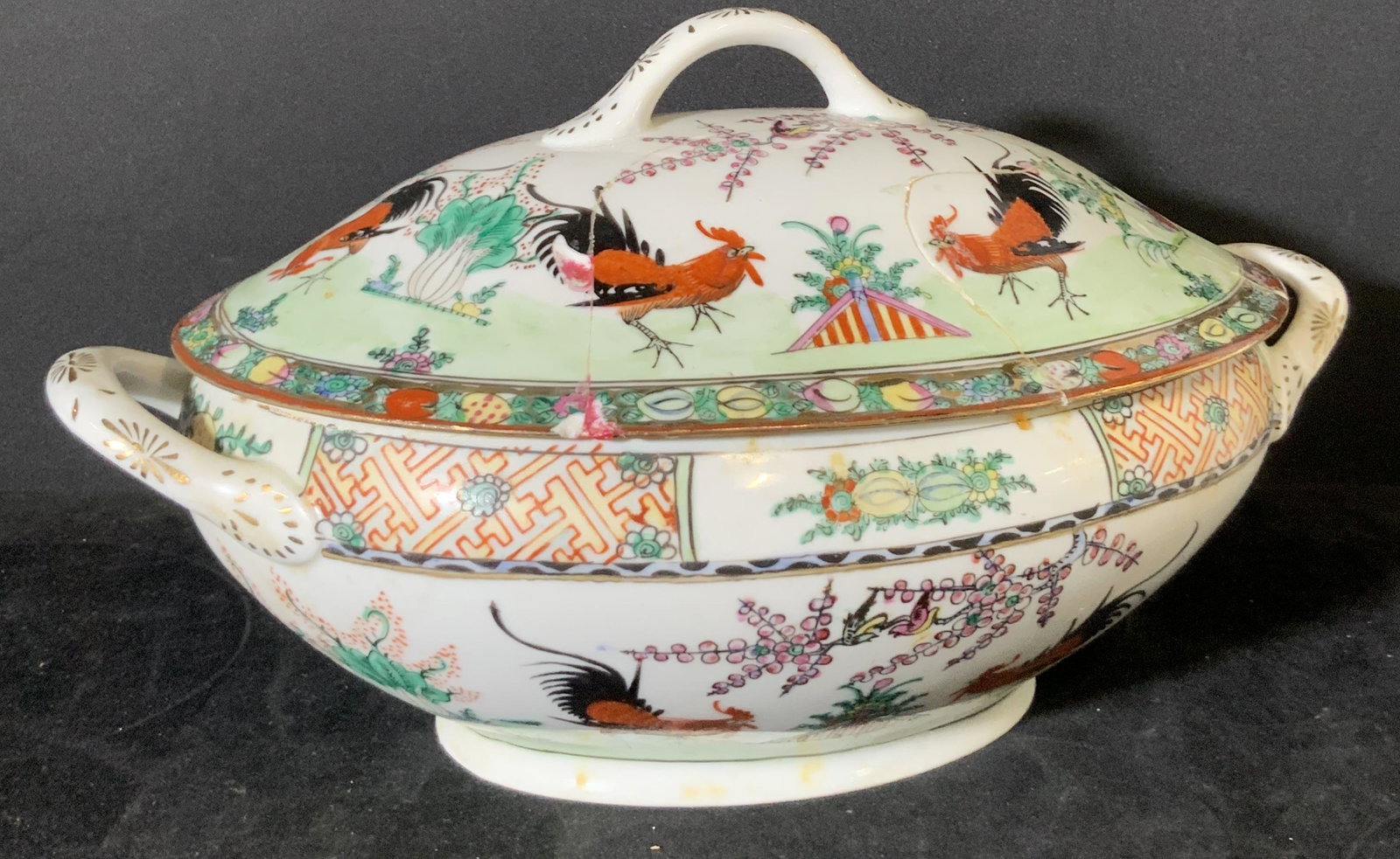 Asian Rooster Hand Painted Porcelain Tureen: White porcelain lidded tureen with hand painted roosters, florals, and other nature inspired motifs. Gilt line work throughout. Tureen is part of a larger lot with the same designs. One large repair t