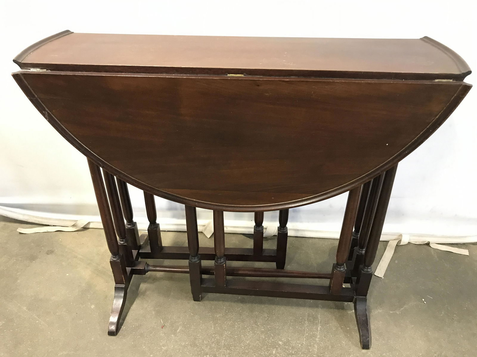 Antique Wooden Drop Leaf Table: Antique wooden table. Drop leafs can be supported by collapsible legs. Table edge is raised. Measures approx 33 inches in diameter, 27.5 inches H. Wear is consistent with age and use. Wood furniture,