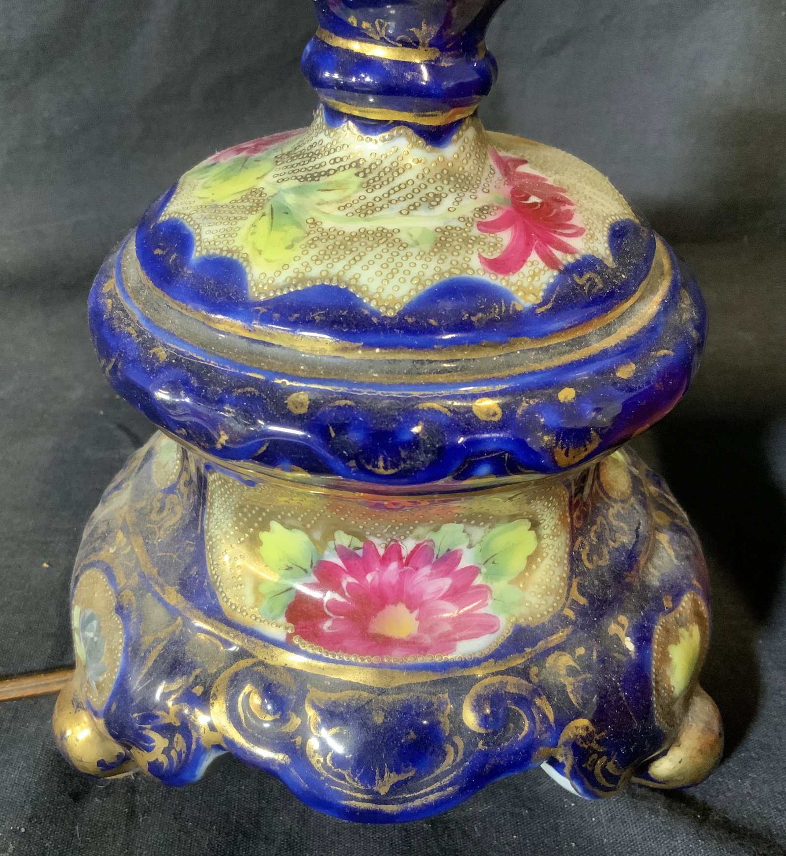 Porcelain Lamp with Beaded Shade: Porcelain lamp with beaded shade, no apparent inscriptions or markings, porcelain part of lamp cracked, floral decor to porcelain base, lamp shade is red with multi colored beaded fringes hanging from