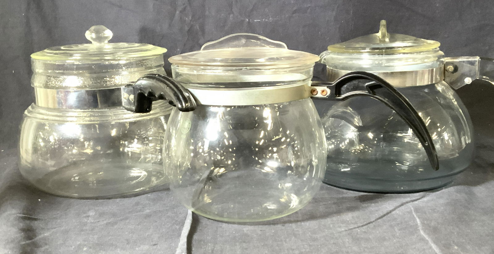 Lot 3 Retro Glass Drip Coffee Pots w Lids: Glass drip coffee pots, ALL have name brands marked, CURTIS FLAMEGLAS, DUNBAR FLAME RESIST, PYREX. Thick walled glass. Curtis pot measures 8 x 6.25 in. Handle is 5 in. L. Properly of Multi Generation