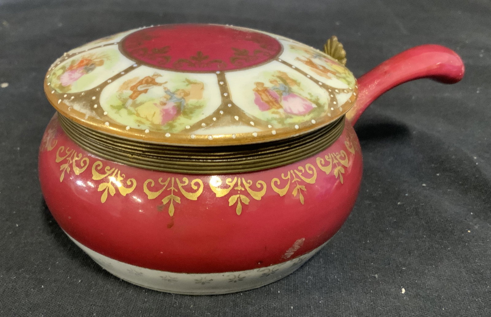 Trademarked Rococo Style Ceramic Vessel: Vintage trademarked ceramic vessel. Vessel is handled and lidded. Lid is decorated with illustrations depicting several couples. Underside is trademarked with two crossed arrows, possibly KALK. Measur