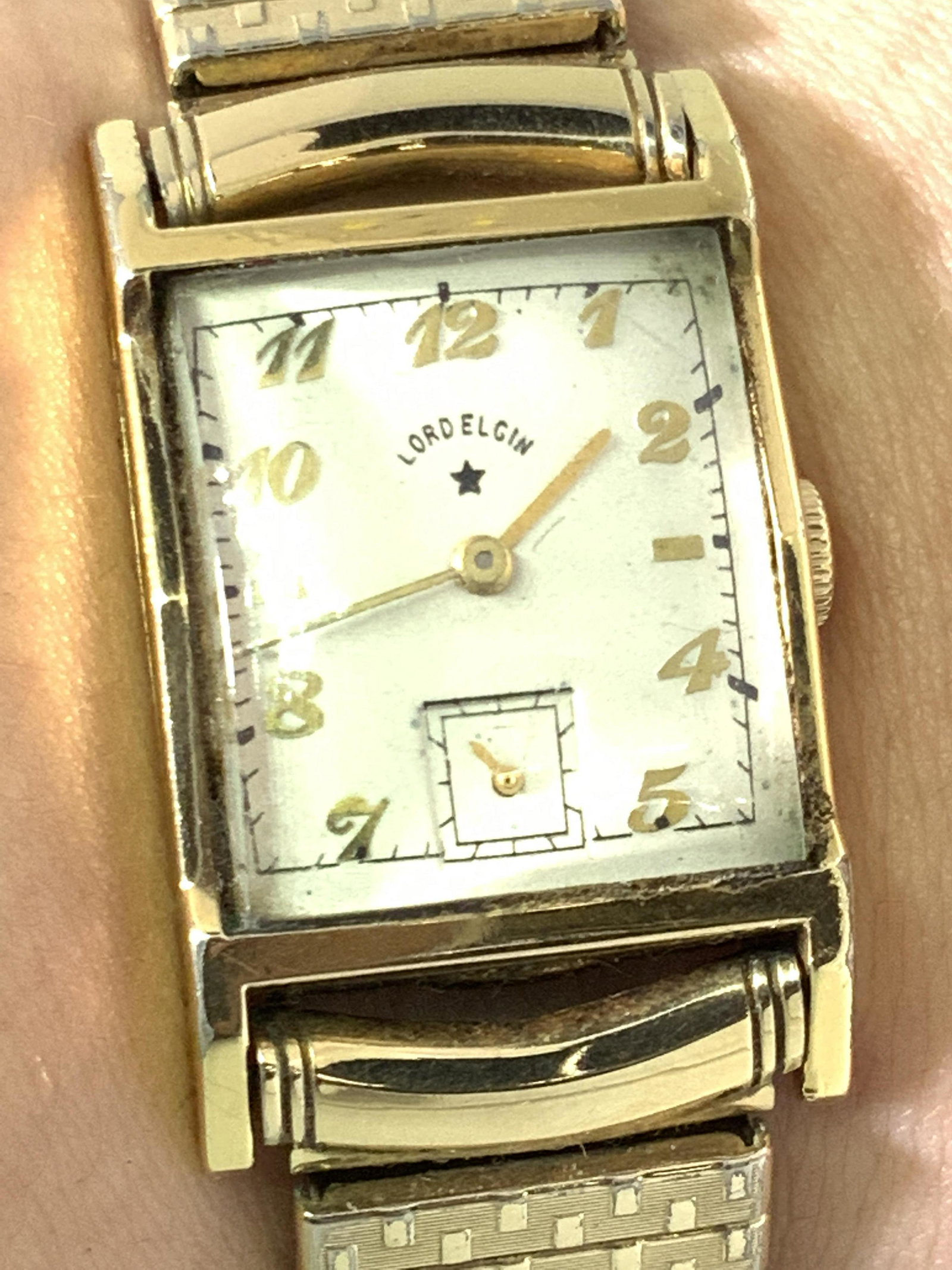 Vintage LORD ELGIN 14k Gold Filled Watch, Org Box: A gold filled stretch watch with stainless steel backing. Piece comes with what appears to be it’s original box. Box reads LORD ELGIN. Velvet style interior, hard acrylic case with crest on lid. The