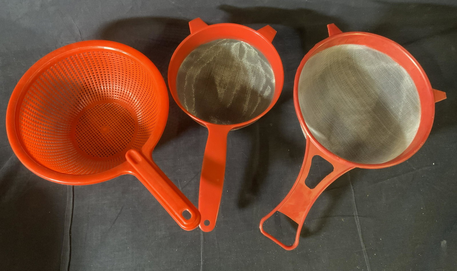 Lot 17 Red Kitchen Strainers, Sieves, & More: Lot 17 Kitchen Strainers, Sieves, & More, inscriptions reads ‘Made in China’, ‘Made in Hong Kong’, ‘Hutzler’, ‘Comet No 1’, ‘Guzzini’, largest measures 5 1/4 x 13 1/2 inches at wid