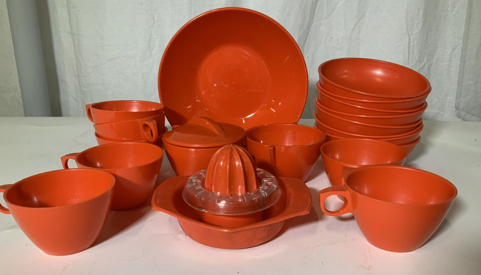 Set 19 Mid Century Breakfastware, Kitchenalia: c. 1960s, 1970s red plastic tableware. Set includes 8 bowls, 7 tea/ coffee cups, lidded sugar bowl, unlidded sugar bowl, orange juice squeezer, larger serving bowl, 8.25 in. W, 2.25 in. Deep. Property