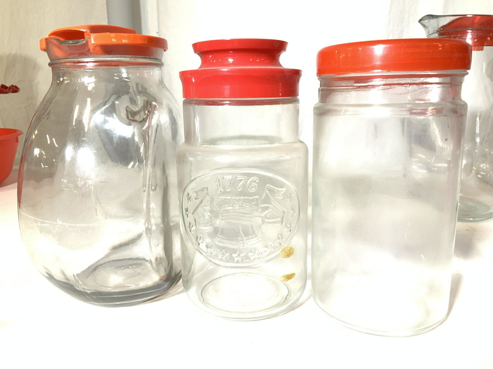 Collectible Vintage Glass Jars, Pitchers, Pots: Group 12 Retro & Vintage Glass kitchenware with red lids or tops. Consists of drop coffee pots, water/ juice pitcher, storage jars, syrup pourers and creamer, coffee press, teddy bear biscuit jar ( pl