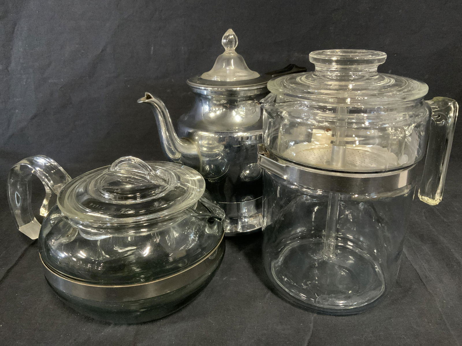 Lot 3 Coffee Brewing Accessories, kitchenalia: Lot includes 1 PYREX glass pot, 1 glass PYREX percolator , and a UNIVERSAL automatic percolator. The percolator is electric but missing the power cord. Property of Multi Generational Brooklyn Collecto