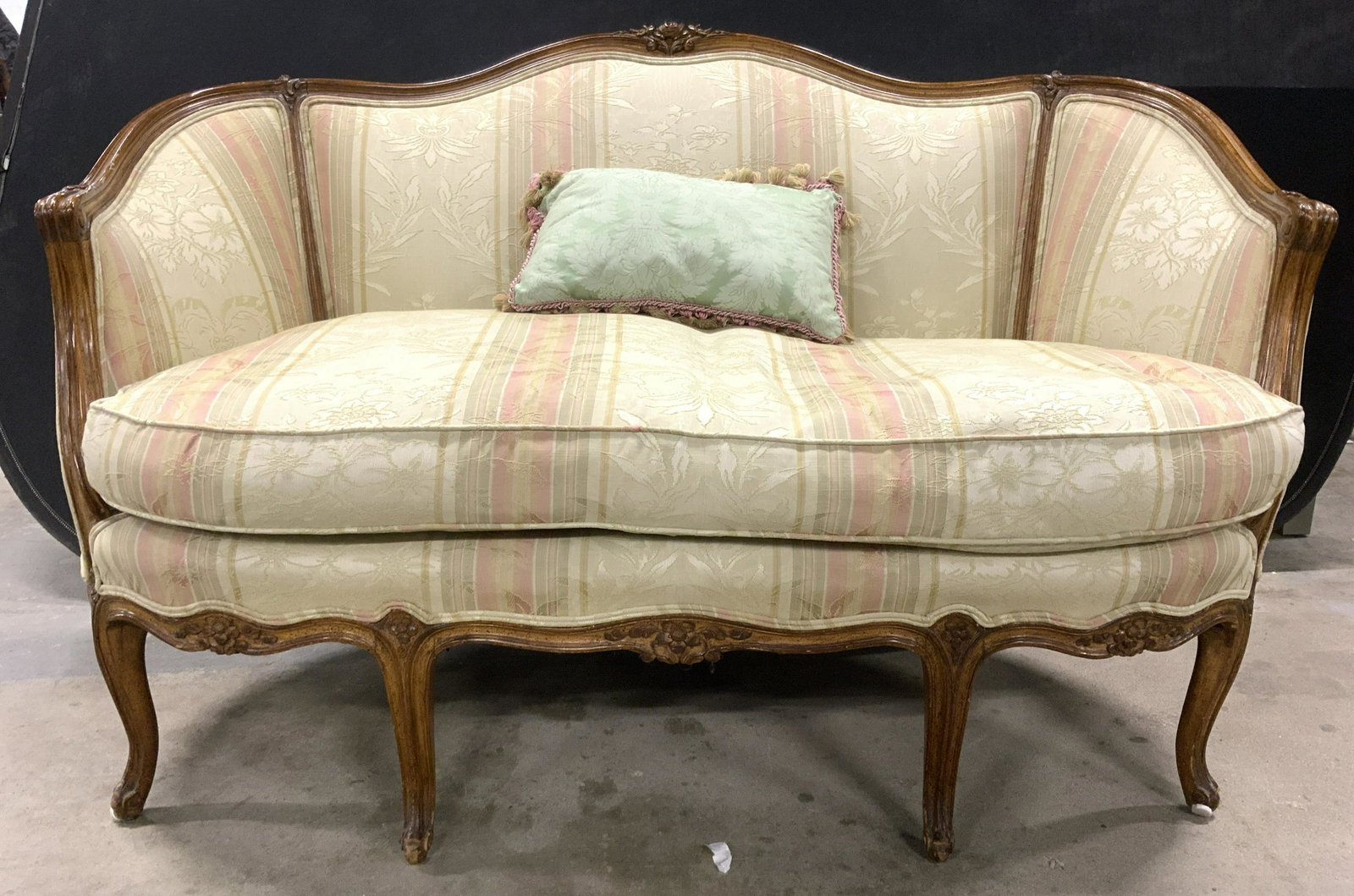LOUIS XV Upholstered Bergere Loveseat: Vintage, possibly antique loveseat with rectangular toss pillow. Loveseat has Louis XV stylings. Sofa has carved floral & leaf detail with 6 legs. Upholstery has double welting in some areas. Pillow h