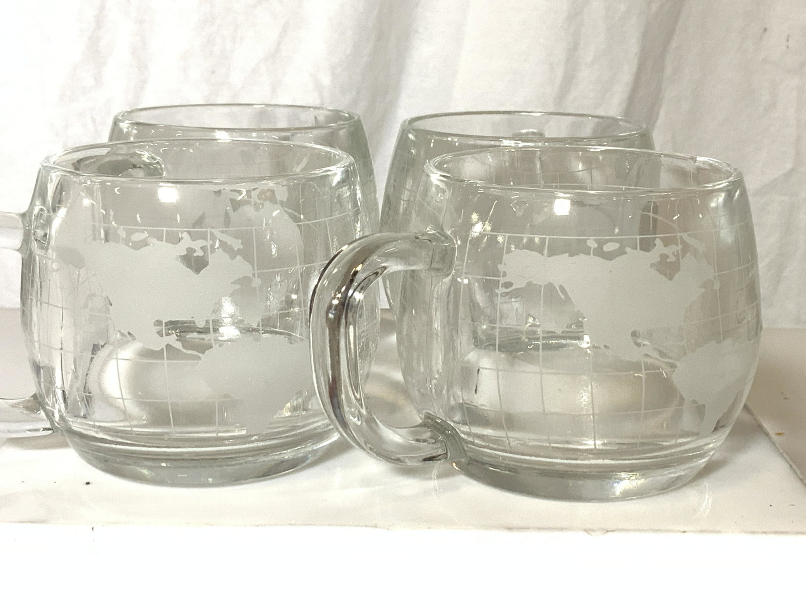 Set 4 Nestle Nestcafé World Map Mugs: Vintage Nestle Nescafé etched world map coffee mugs, a collectible. Thick walled. Hallmarked THE NESTLE CO , INC. 4.5 in W3.in HT. Property of Multi Generation Brooklyn Collector’s Estate Vintage N
