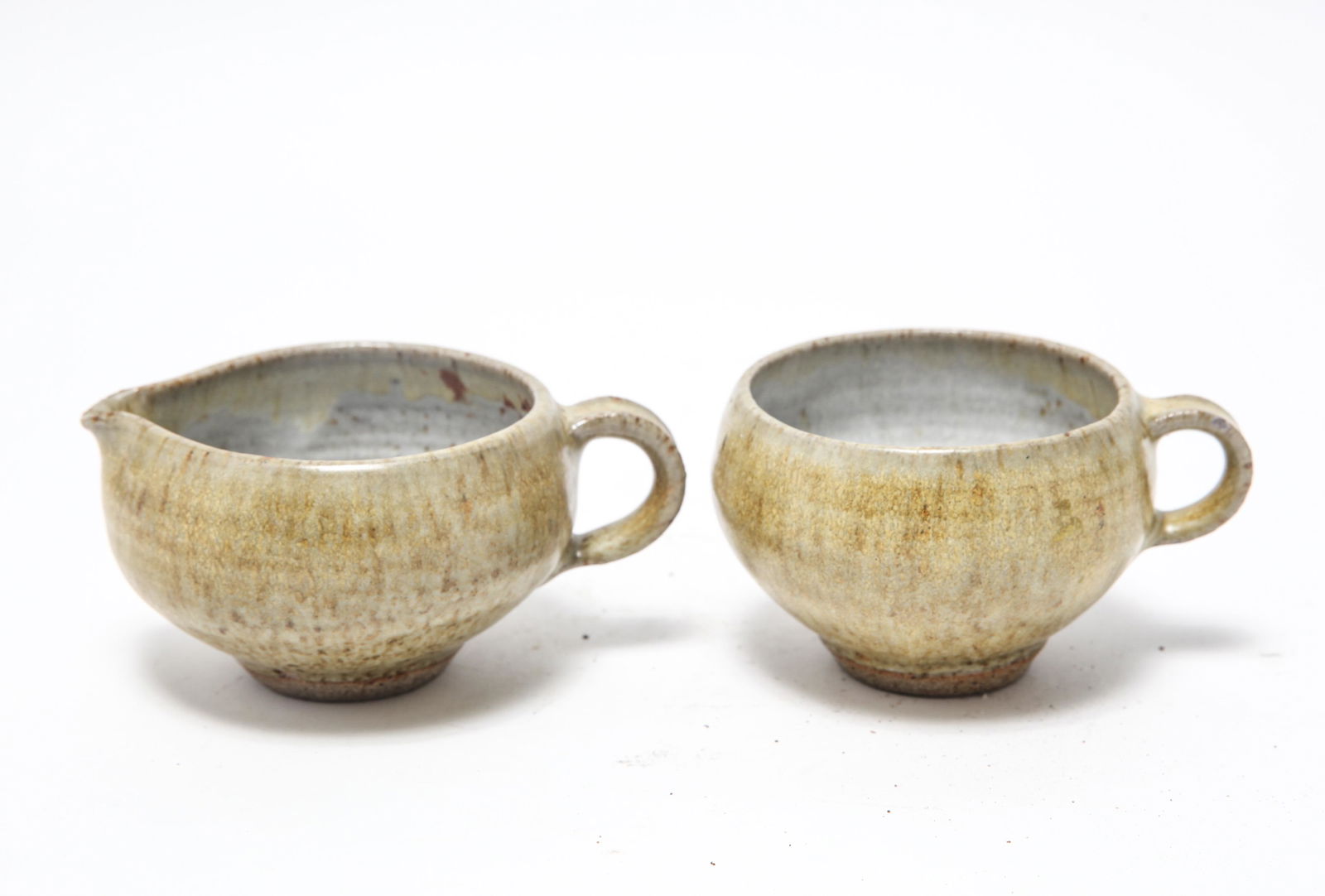 Karen Karnes Style Pottery Creamer & Sugar Bowl: Karen Karnes Style Pottery Creamer & Sugar Bowl Manner of Karen Karnes (American,1925-2016) stoneware art pottery cream pitcher and sugar bowl, unmarked. 2.75" H x 5.5 over handle to spout.