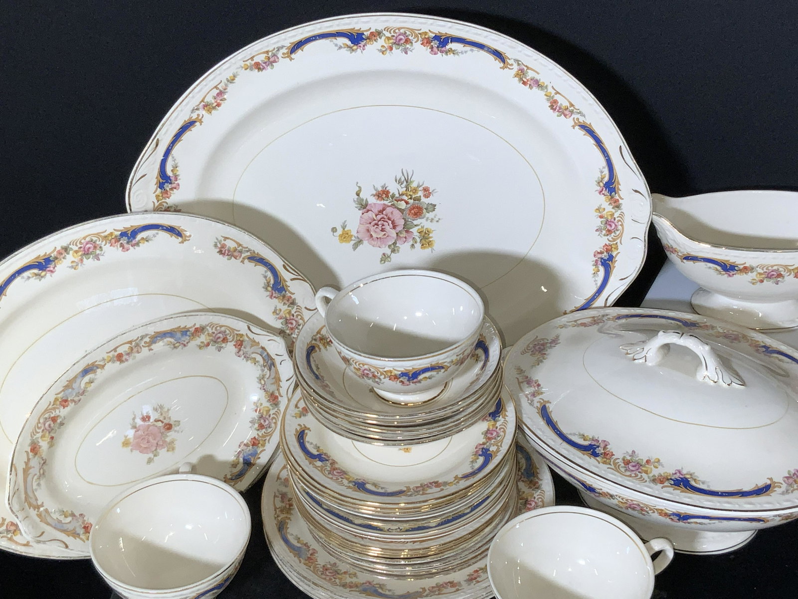 Set 30 HOMER LAUGHLIN Porcelain Dinnerware: White eggshell porcelain dinnerware. 30 pieces in total. 4 teacups, 6 serving platters / vessels, 5 bowls, 15 plates (two sizes). Each piece has the same patterns, florals and gilt accents. Some under