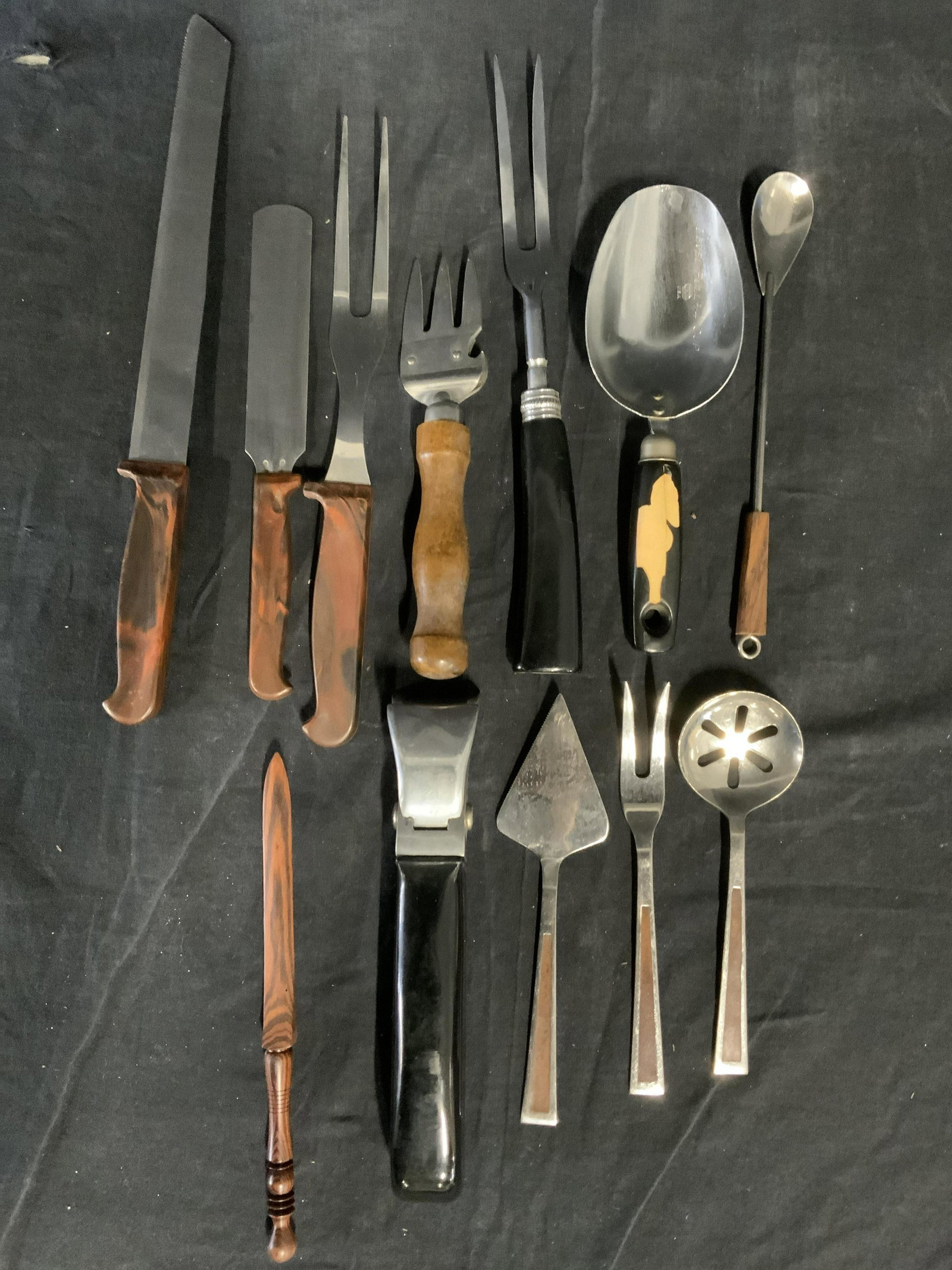 Lot 12 Vintage Cutlery & More: Lot includes 12 pieces of cutlery. 4 forks, 3 spoons, 2 knives , 1 handle, 1 Pie Handle, 1 Wooden Sword shaped accessory. Largest measures approx 7.5 inches H, and 1.5 inches wide. Wear is consistent 